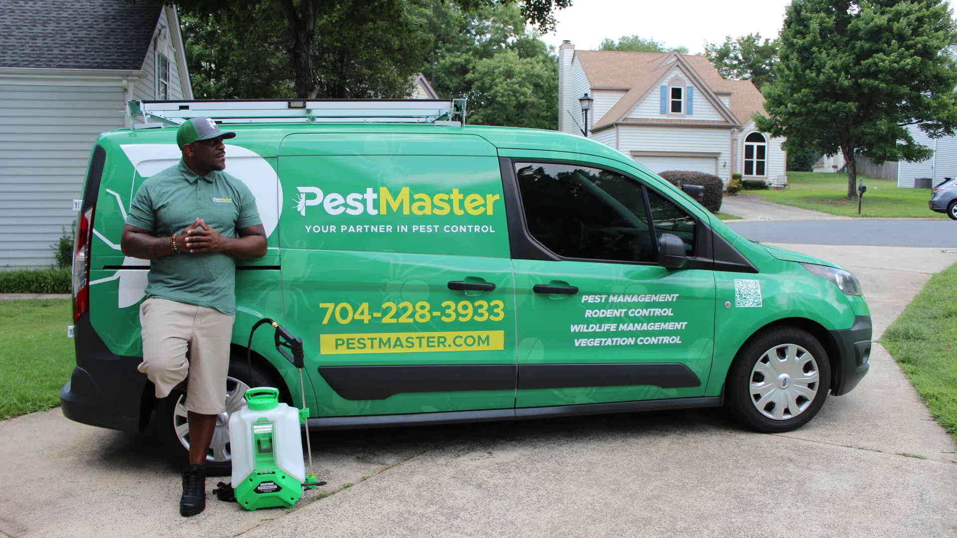 PestMaster technician standing next to green service van in South Charlotte