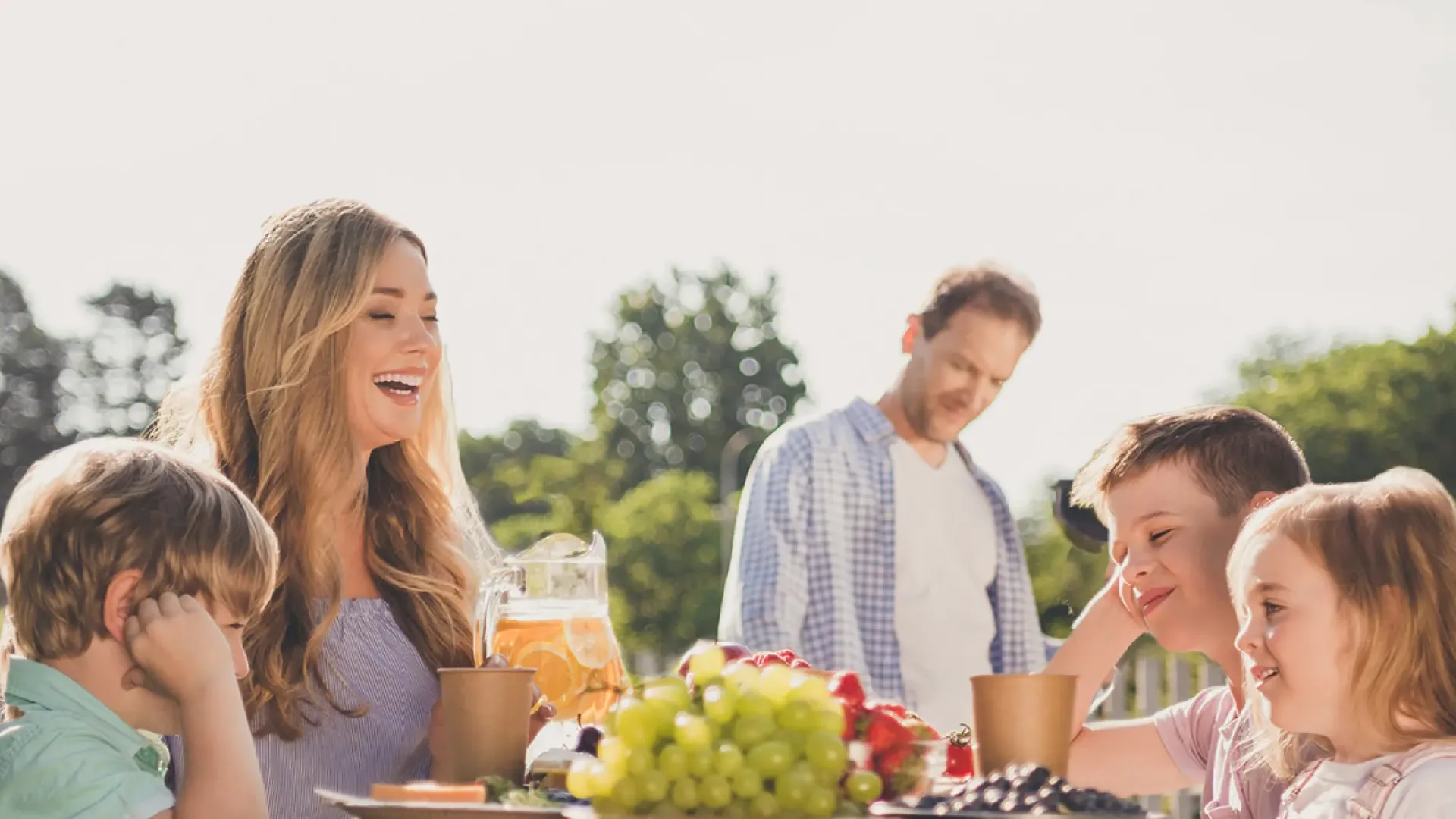a group of people sitting on a deck with food and drinks