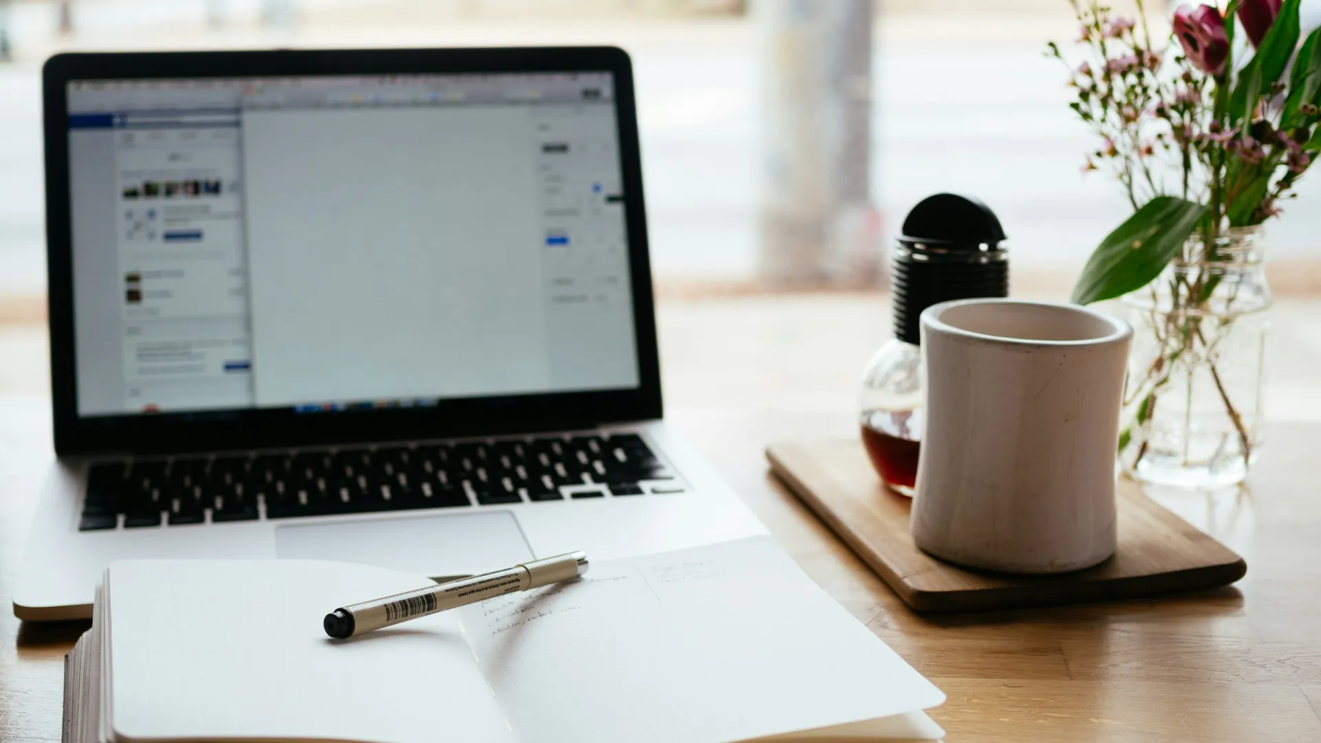 a laptop and a pen on a table