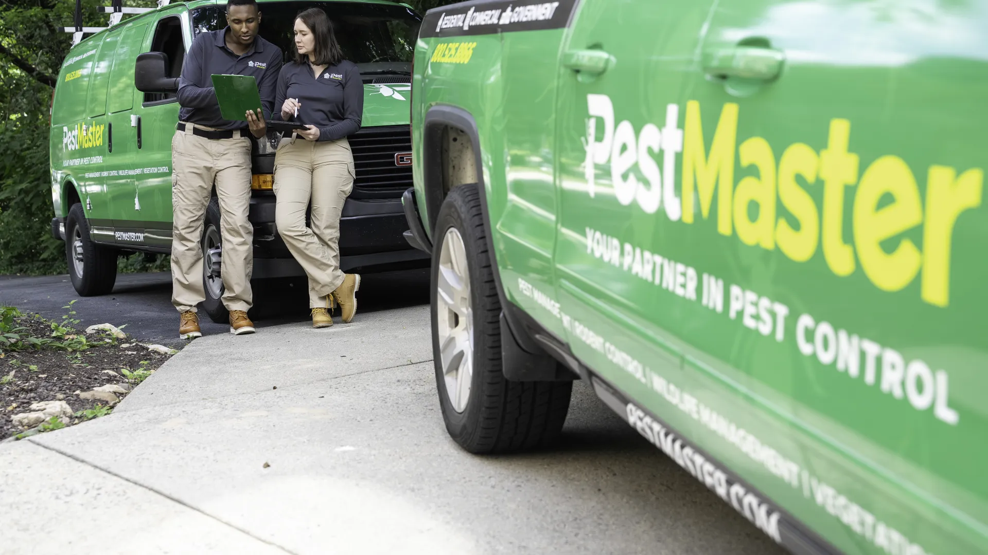 a man and woman standing next to a green truck