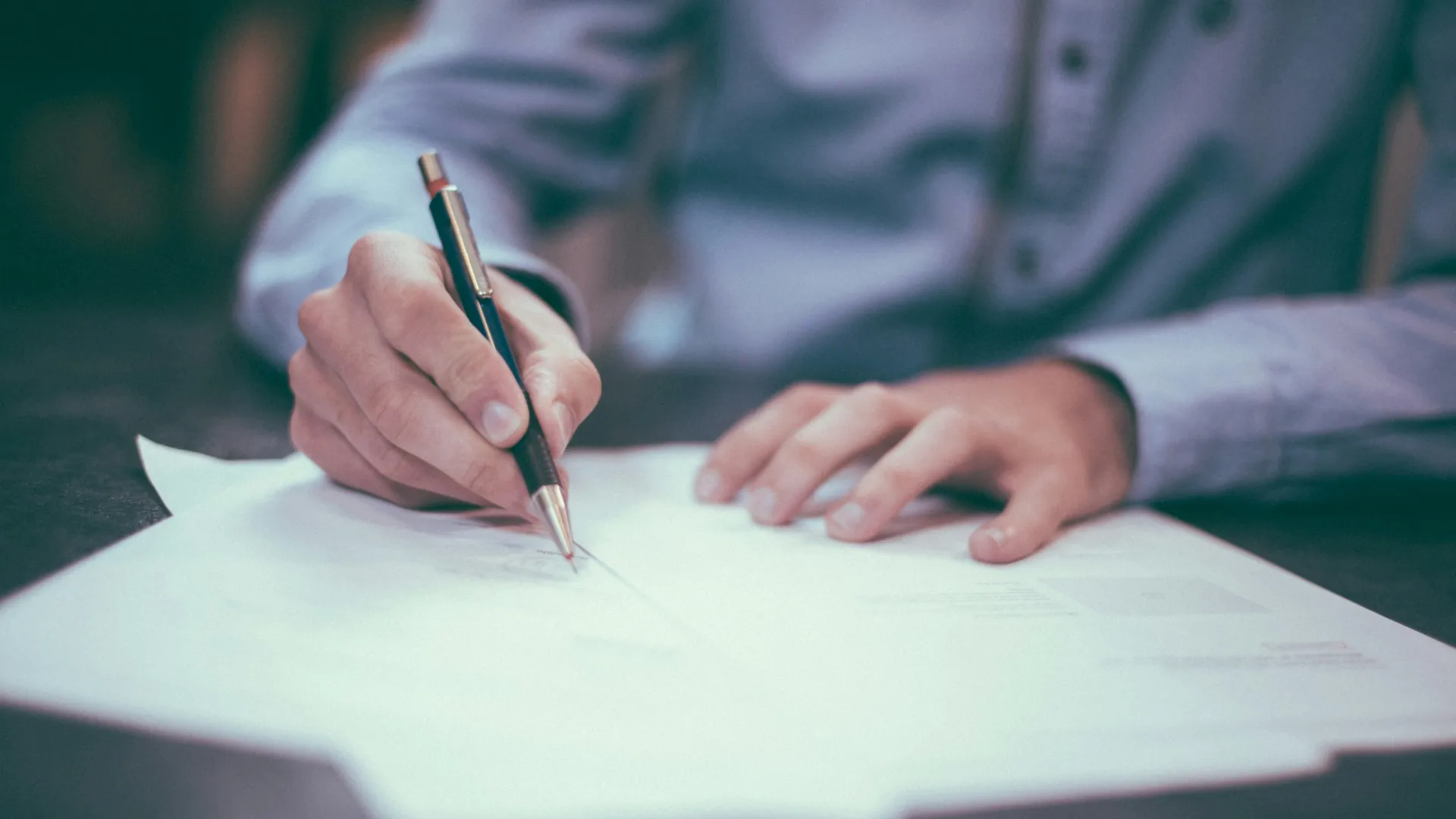 a person writing on a piece of paper