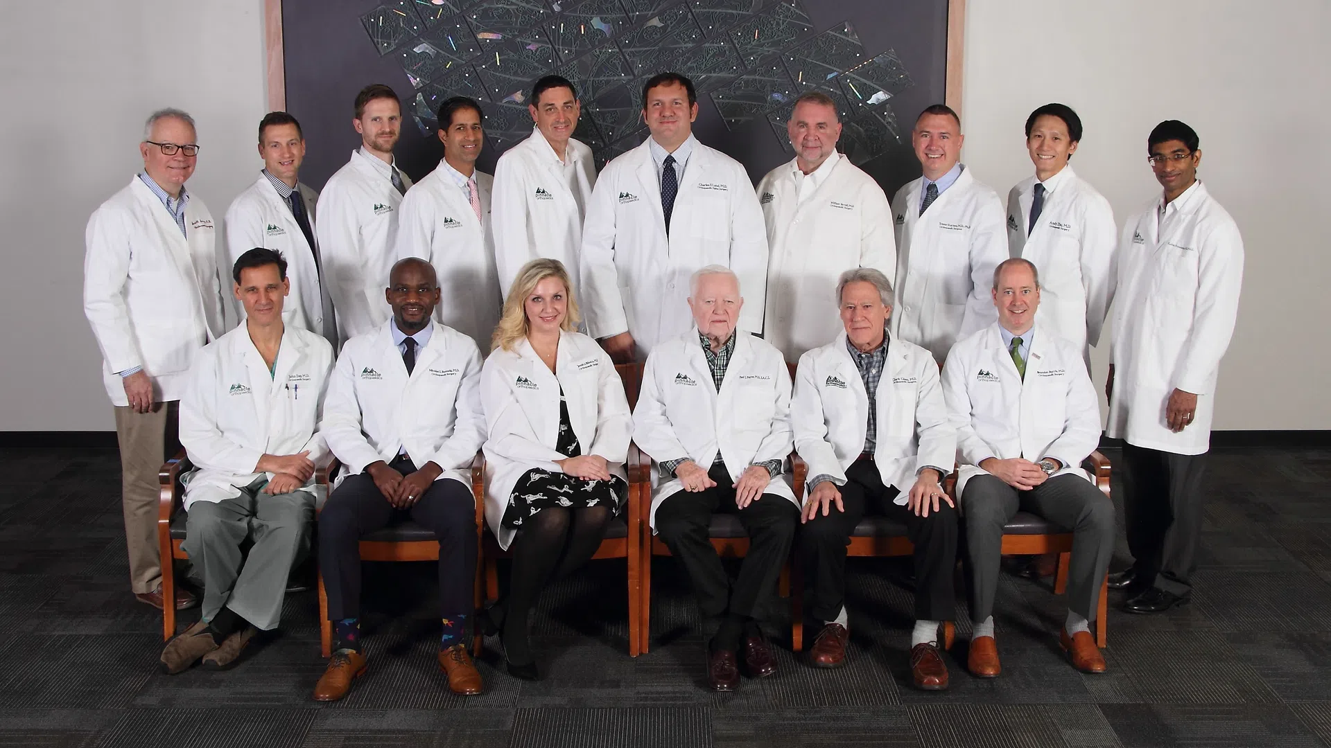 Group portrait of diverse medical professionals in white lab coats posing together indoors