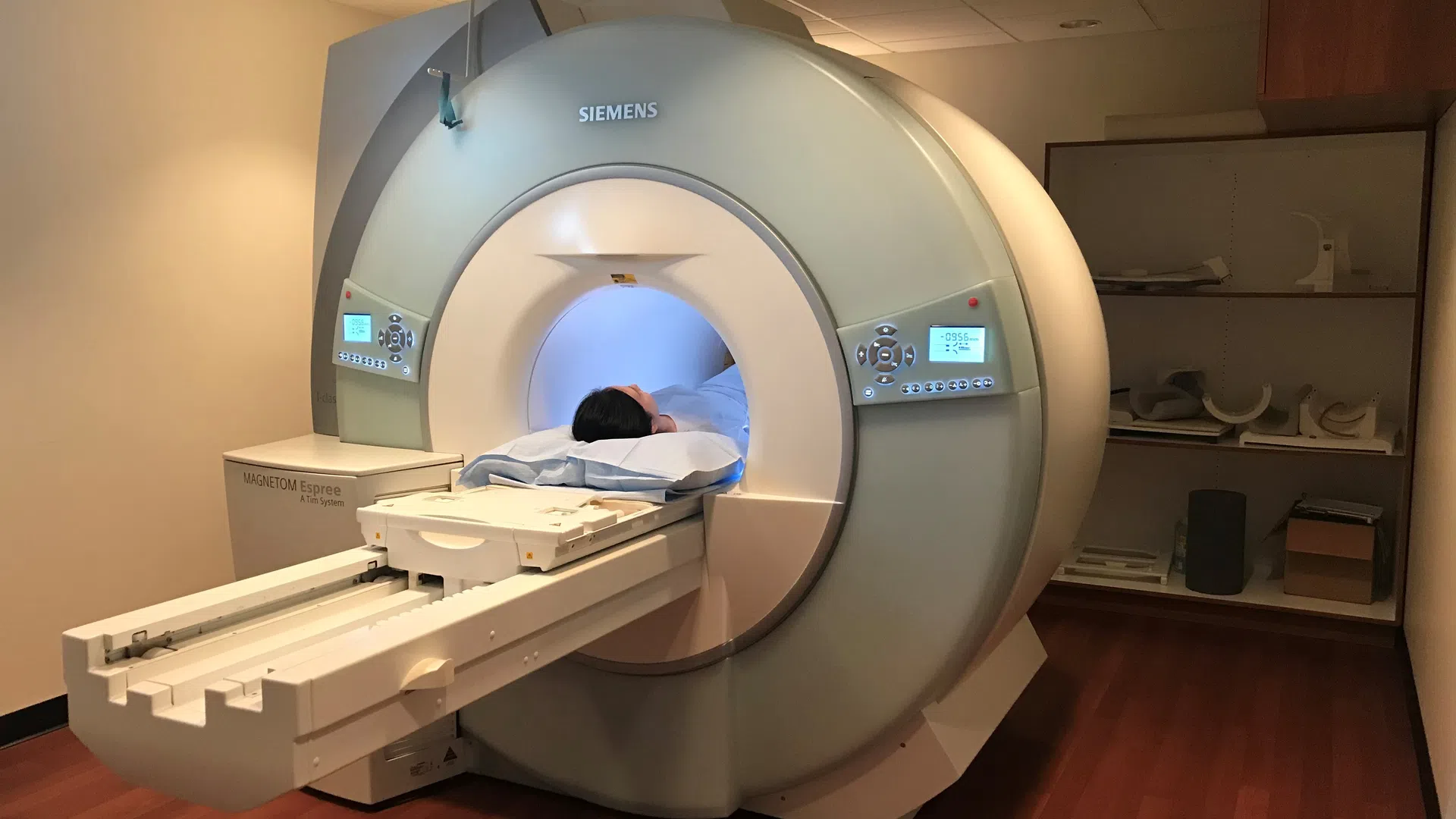 Patient undergoing MRI scan inside a Siemens MAGNETOM MRI machine in a medical imaging room.