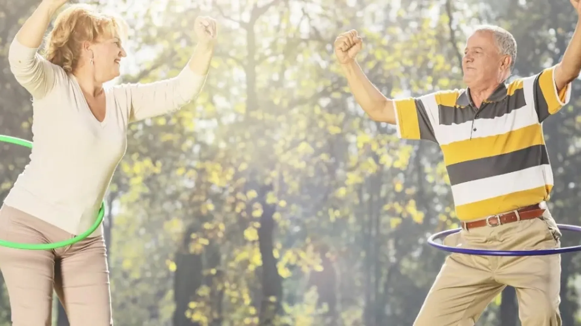Group of diverse people forming a circle with their hands reaching towards the center against a clear blue sky.