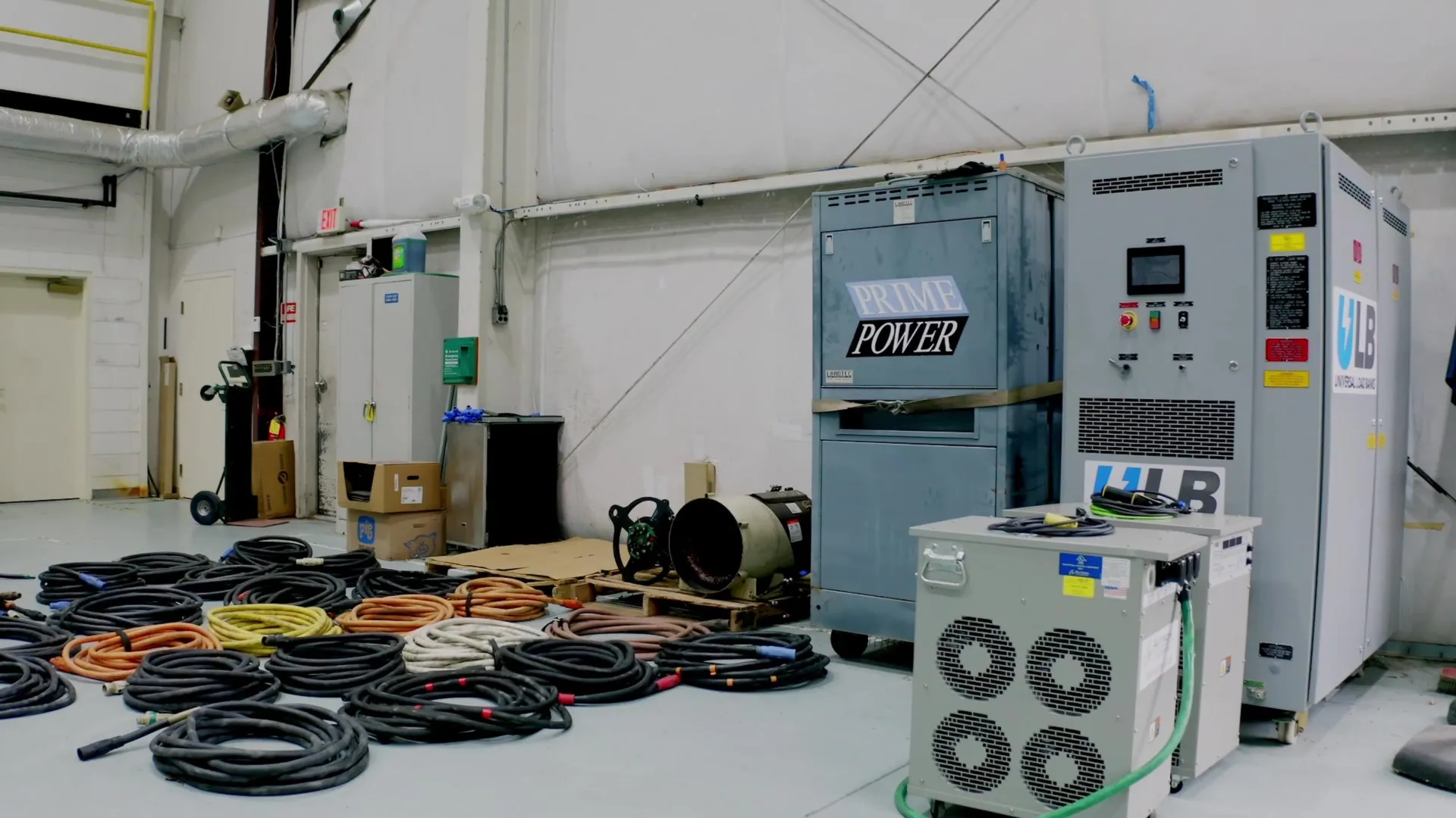 Industrial room with coiled cables on the floor and electrical equipment labeled Prime Power and VLB Systems.