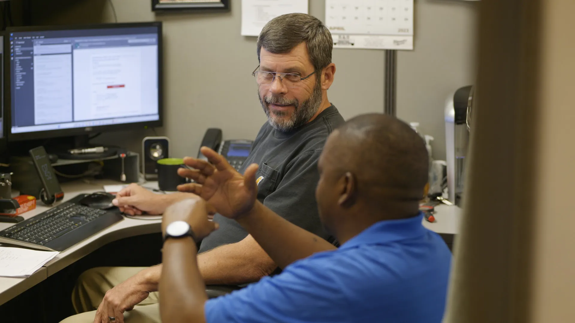 a man showing another man something on the computer