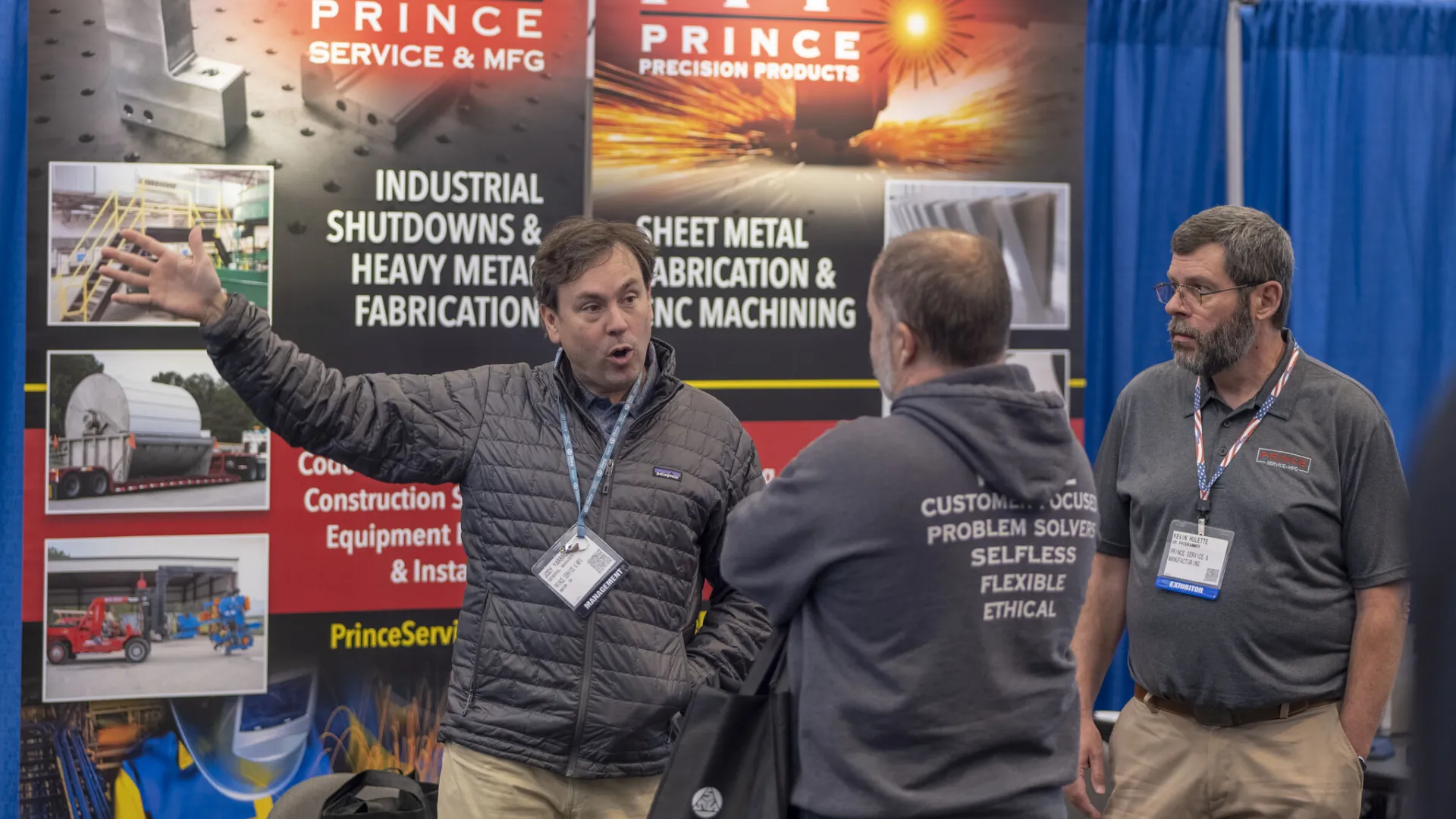 a group of men standing in front of a large poster