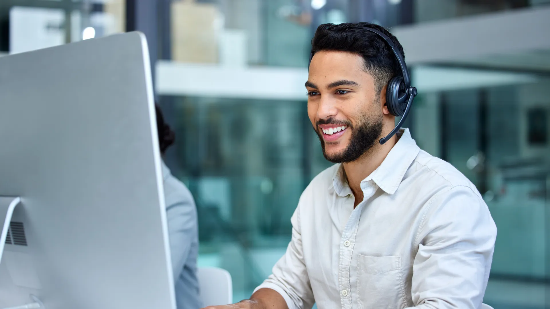 a man wearing headphones and sitting at a desk with a laptop