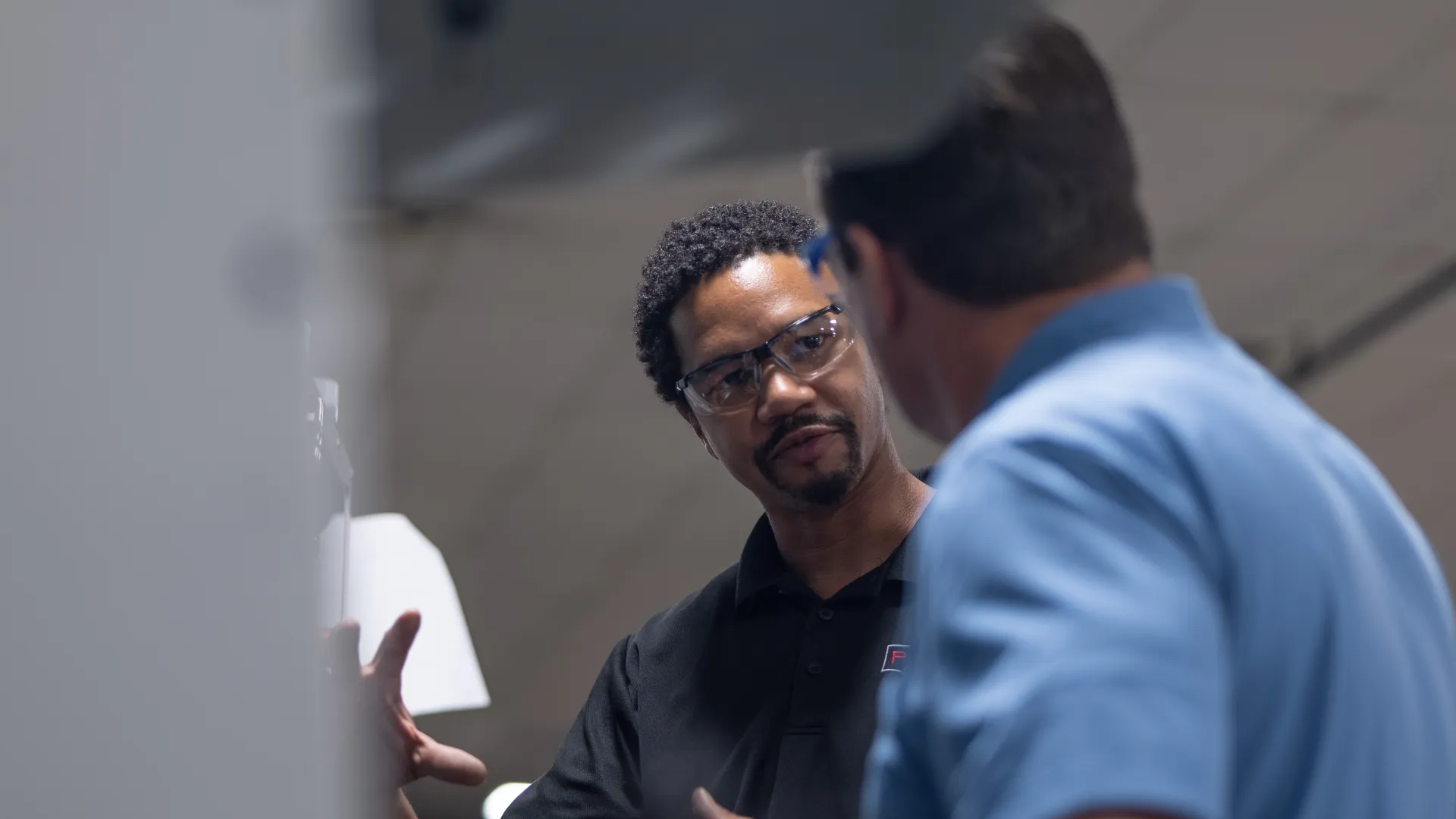 a man holding a paper and a man looking at him