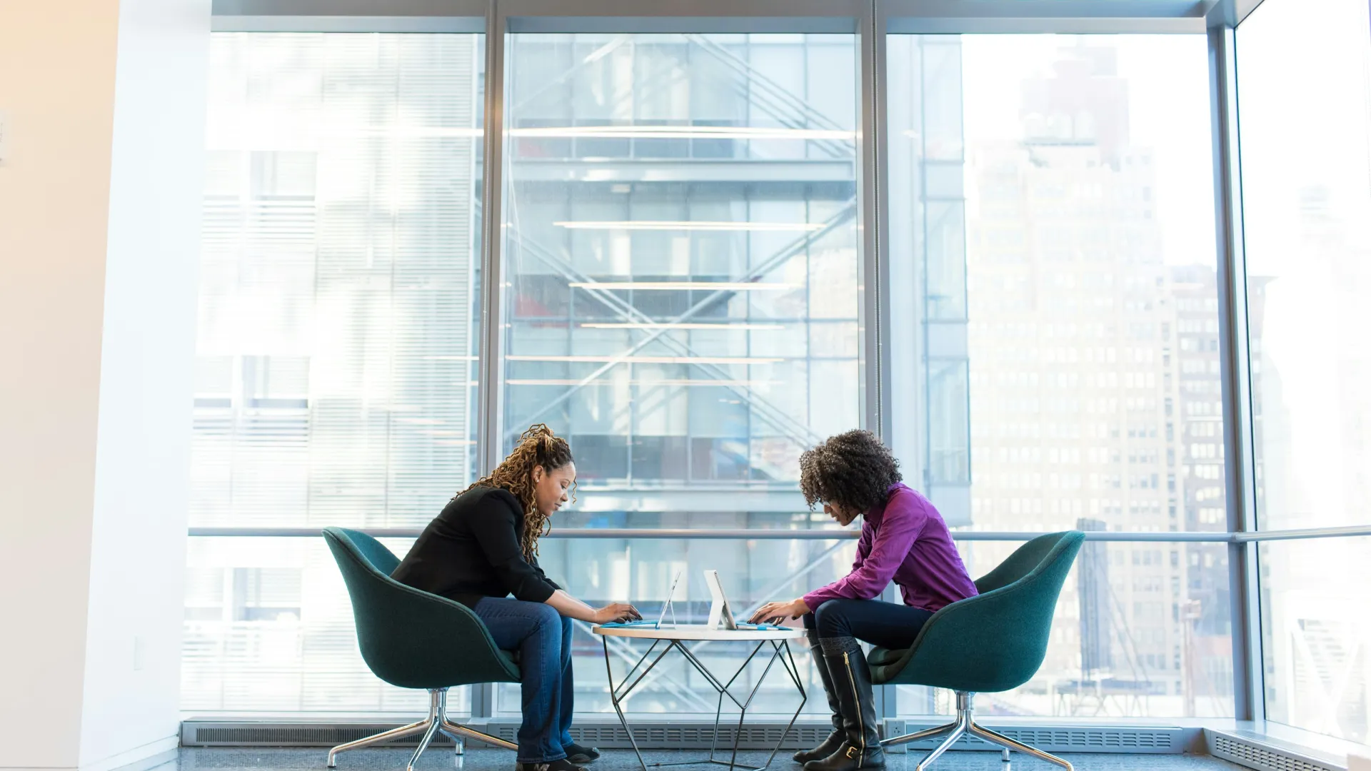 a woman and a man sitting at a table with a laptop