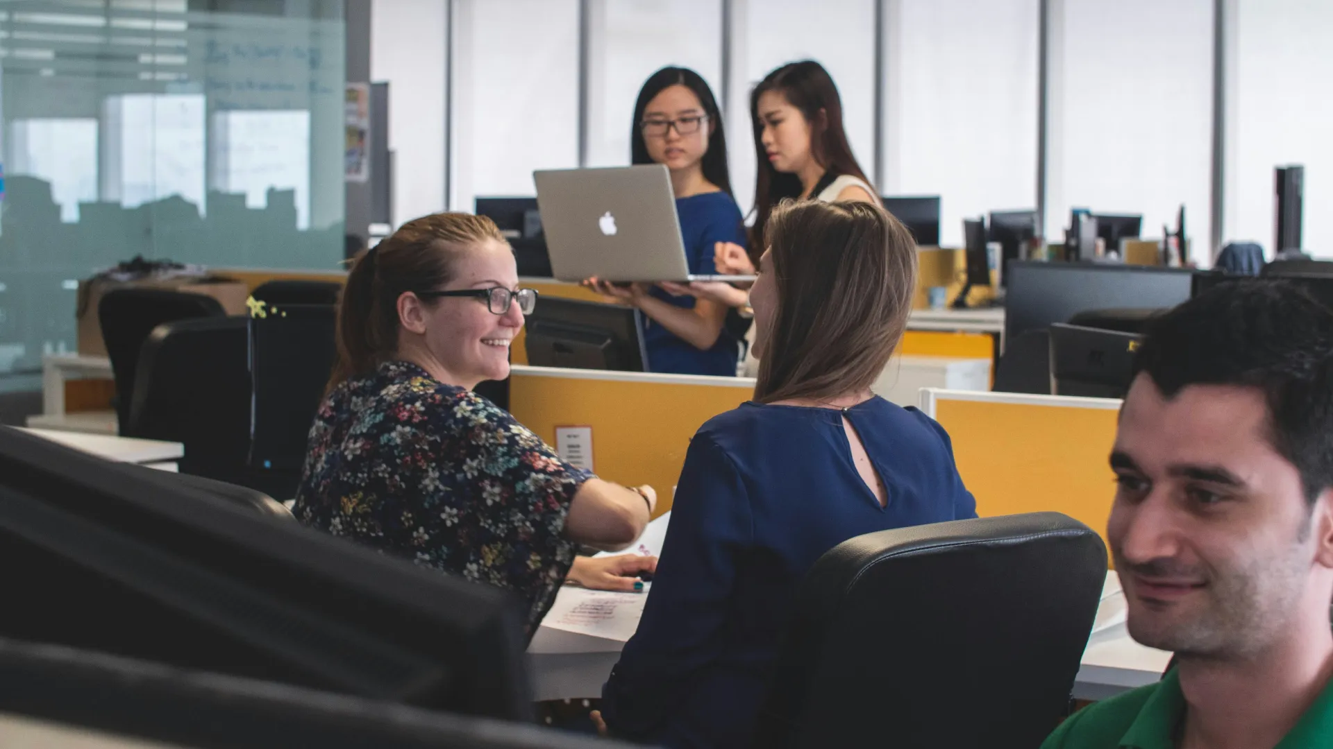 a group of people sitting at desks in a room