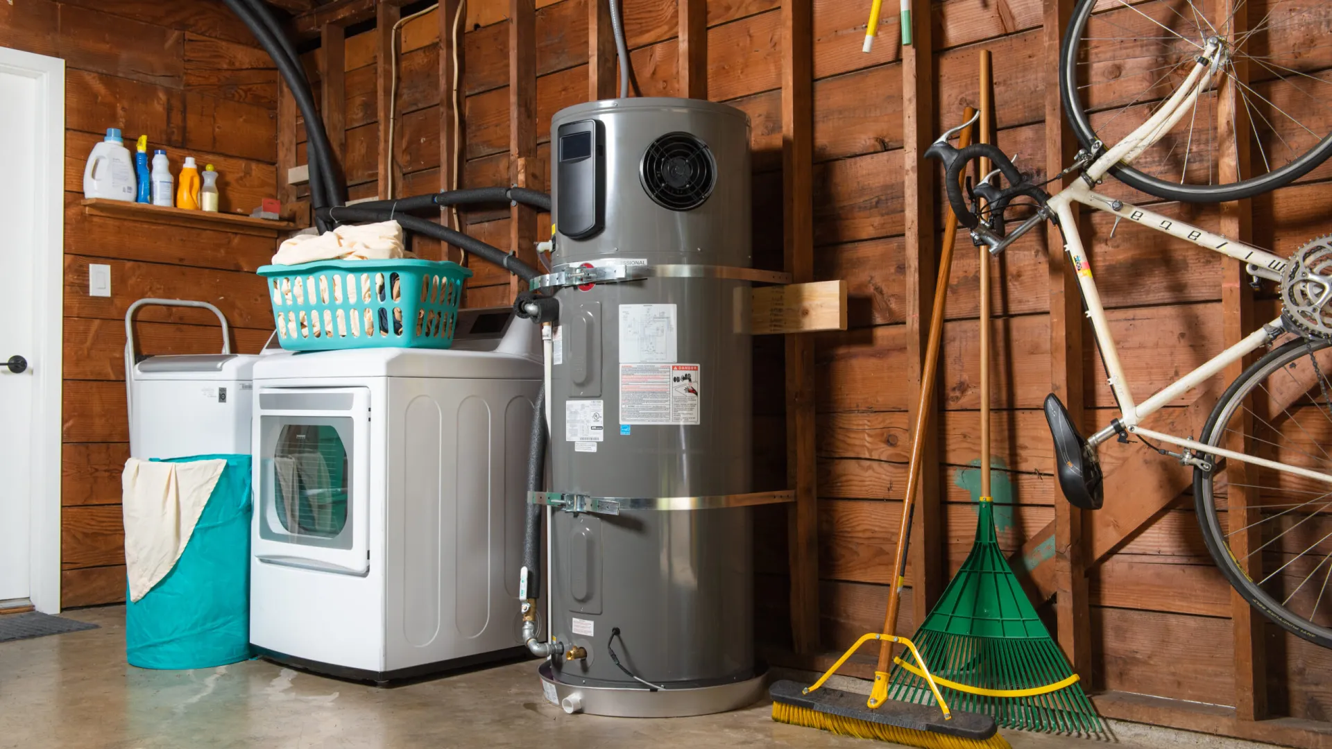 Organized garage showcasing a washing machine, water heater, and cleaning supplies.