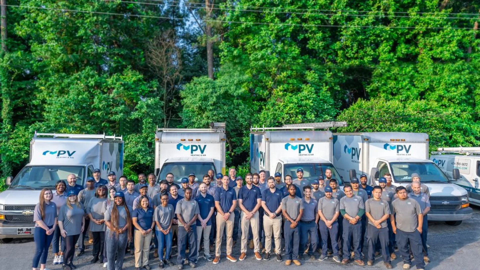 a group of people standing in front of a line of trucks