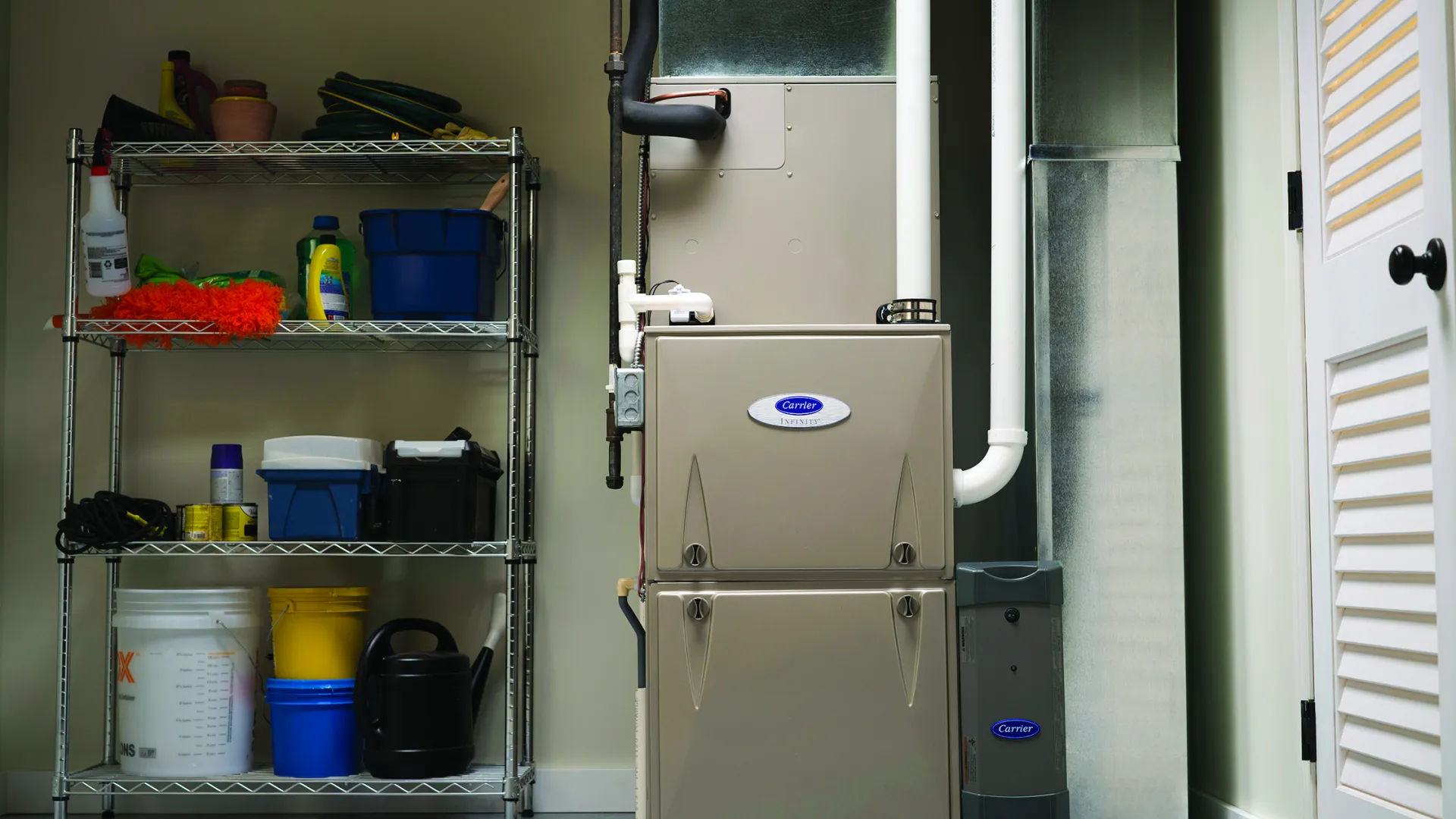 A modern furnace installed in a garage with organized shelves of cleaning supplies and tools.