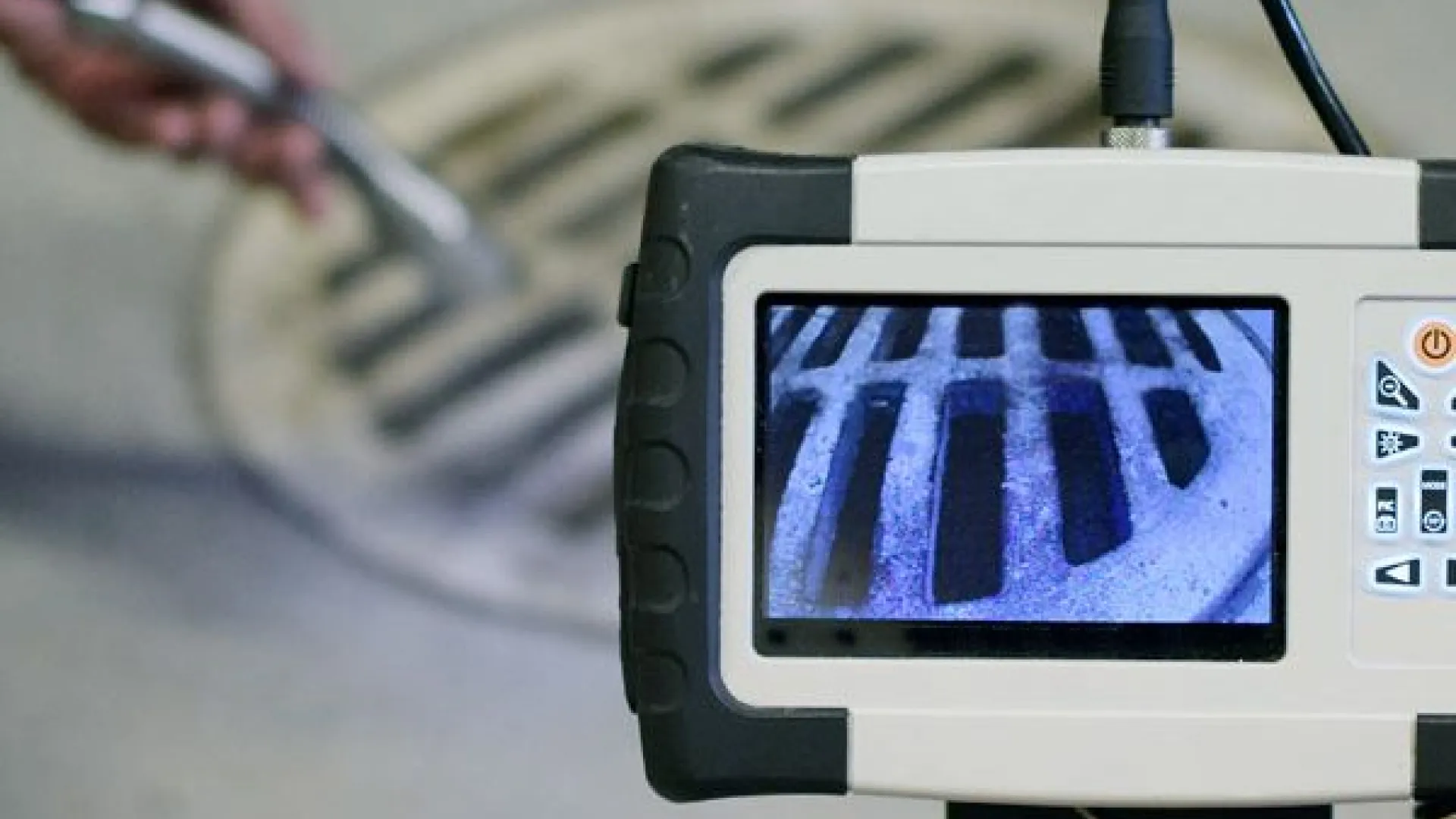 A close-up view of a sewer inspection camera displaying a drain's interior details.