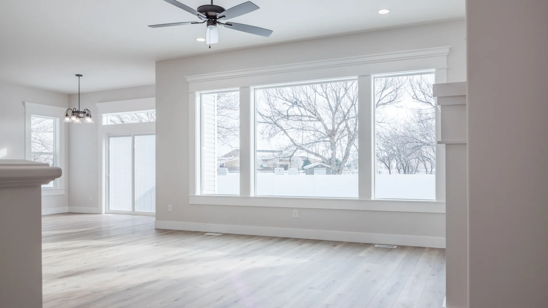 a room with a wood floor and a ceiling fan and a window