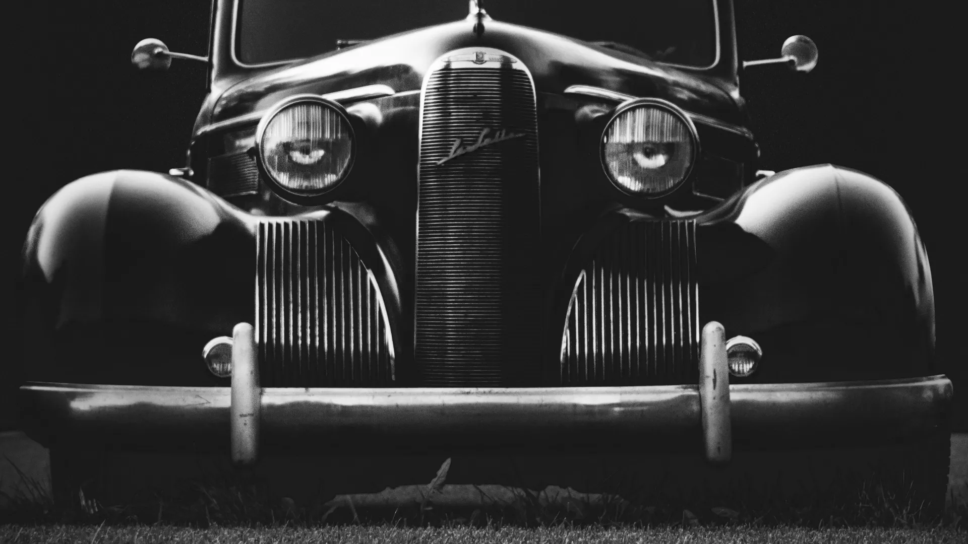 a vintage car parked on grass