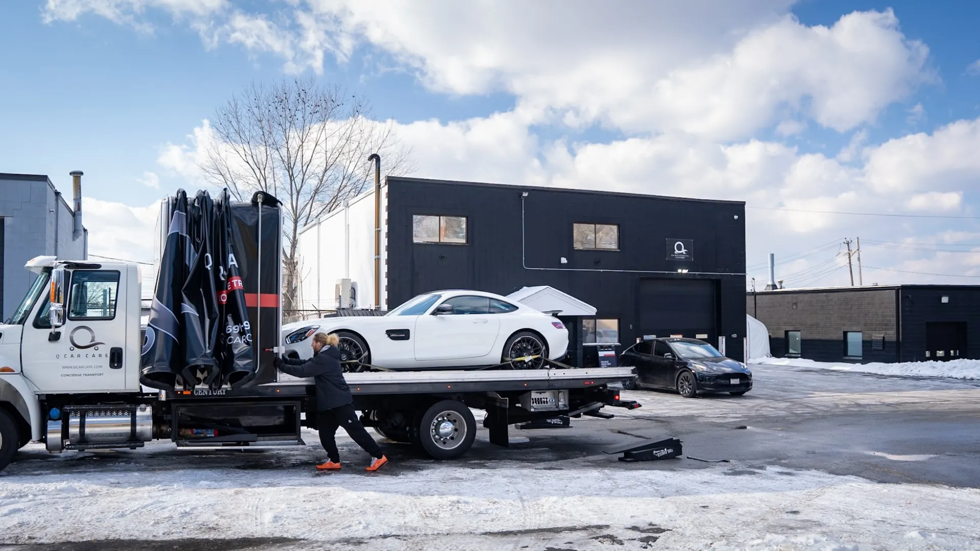 a person pushing a car on a trailer