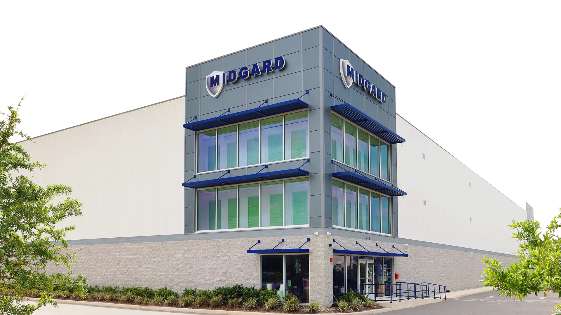 Modern Midgard warehouse building with glass windows, blue accents, and surrounding greenery on a clear day