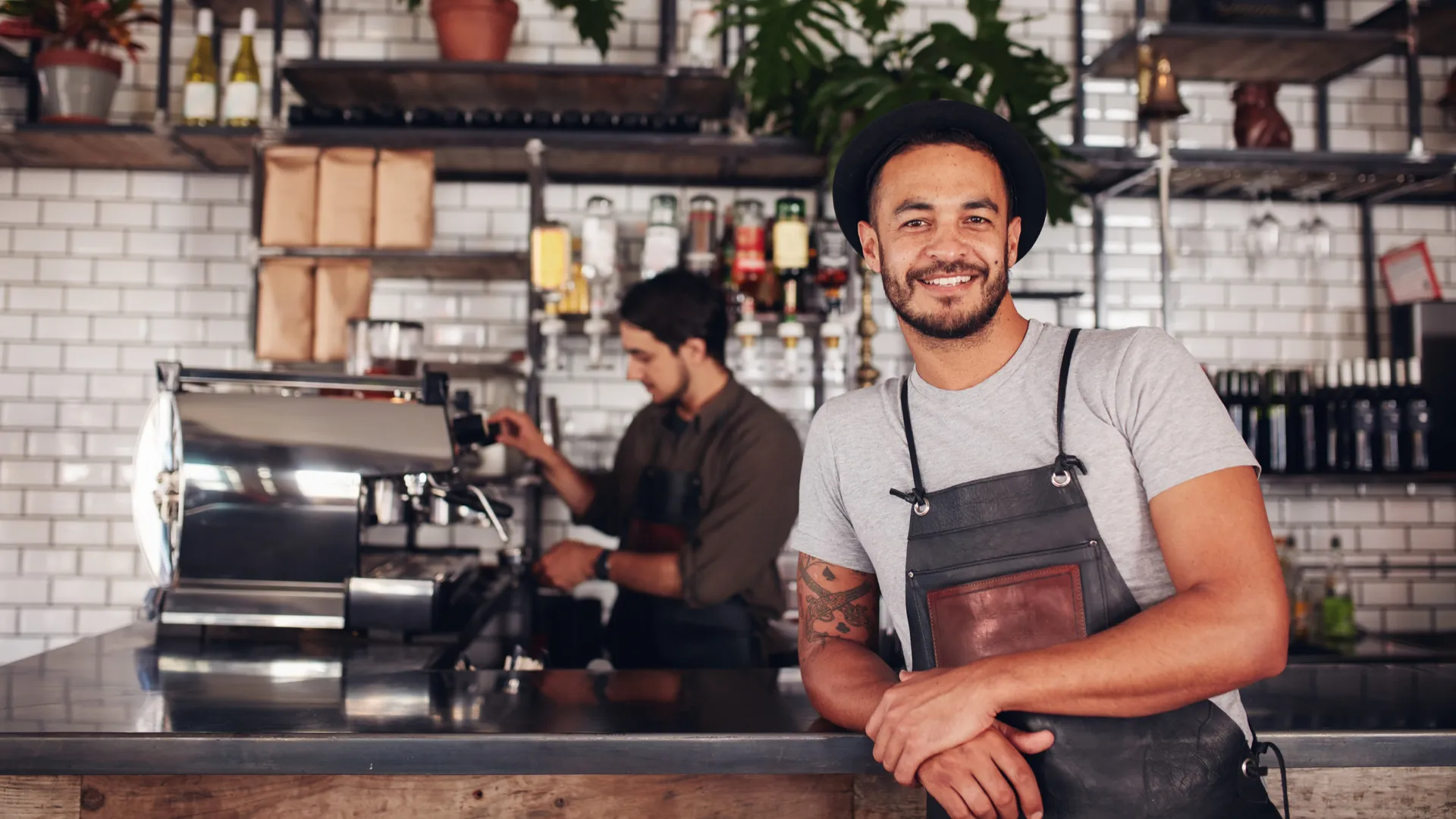 a person with a hat and a beard sitting at a table