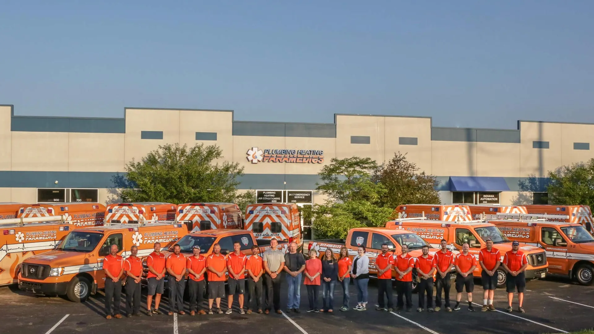 a group of people in orange shirts standing in front of a building