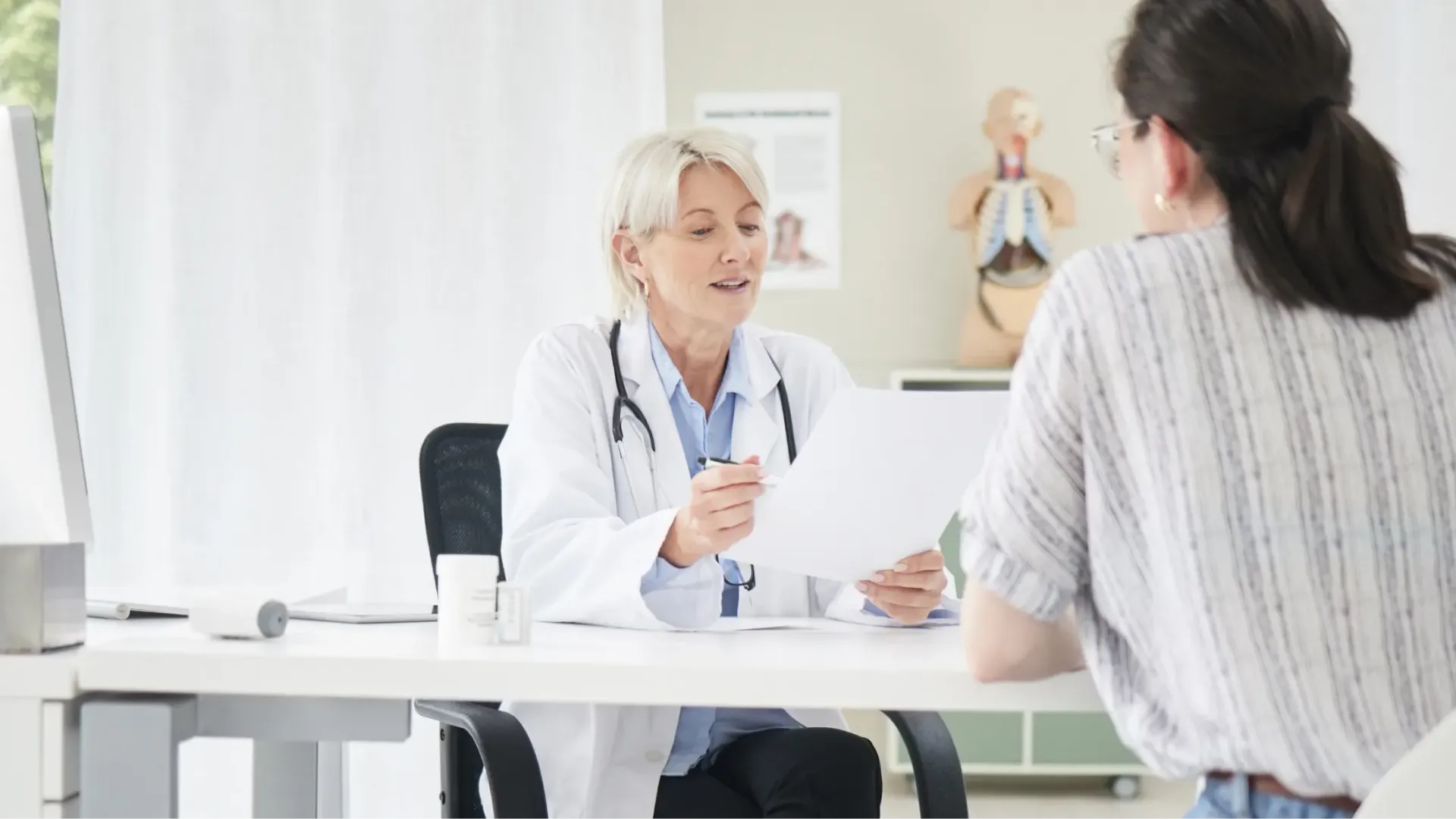 Modern home office setup with a wooden desk, ergonomic chair, computer with green LED lights, and airplane wall art.