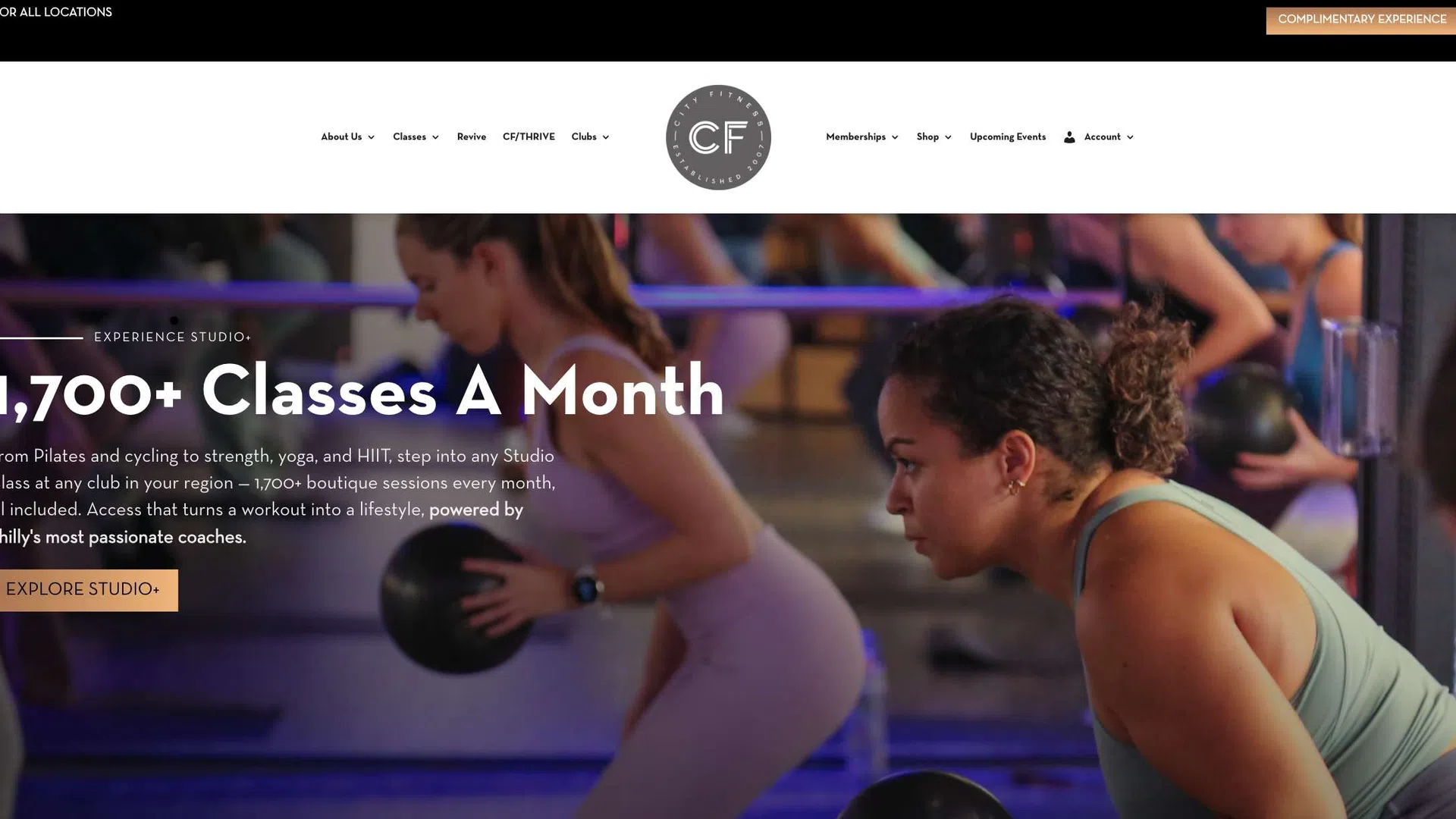 Women doing strength training with medicine balls in a fitness studio with purple lighting