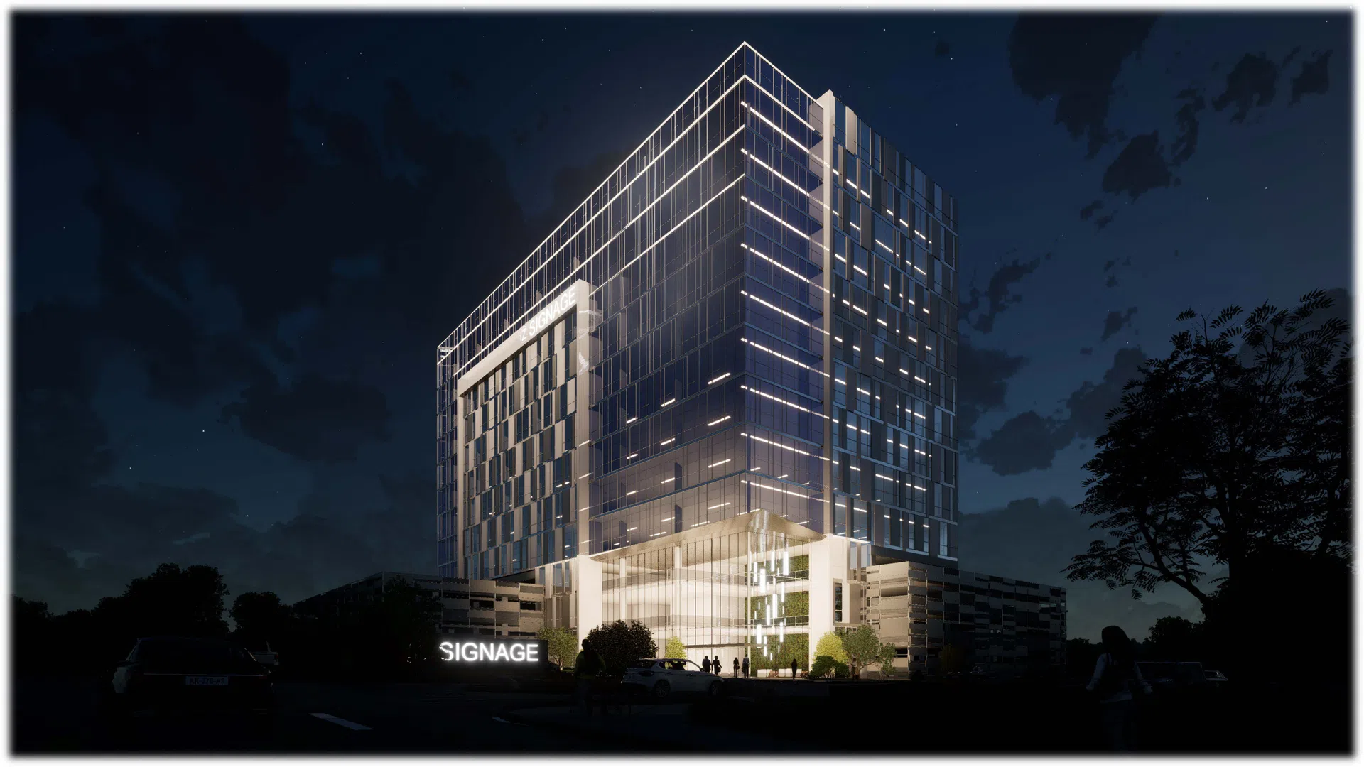 Modern glass office building illuminated at night with clear architectural lighting and surrounding trees.