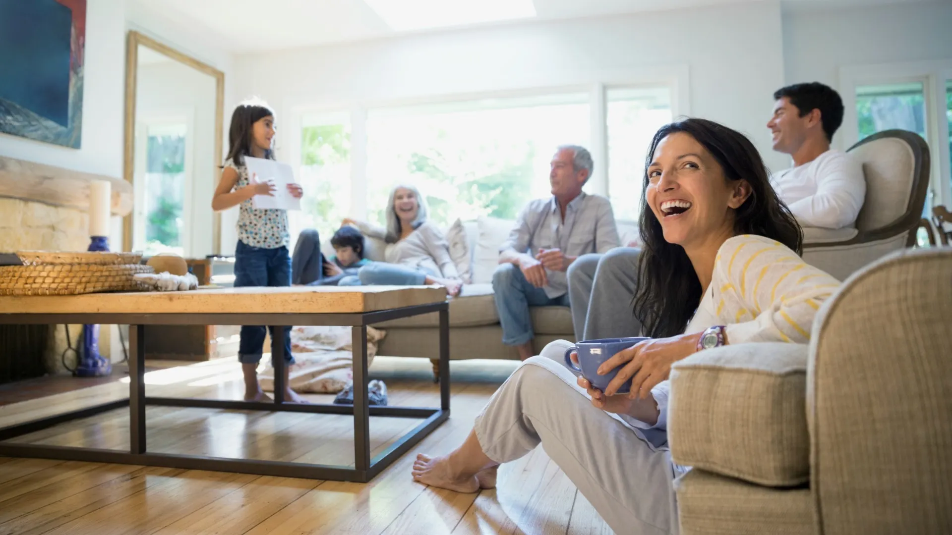 Happy multigenerational family enjoying time together in a bright, cozy living room with natural light.