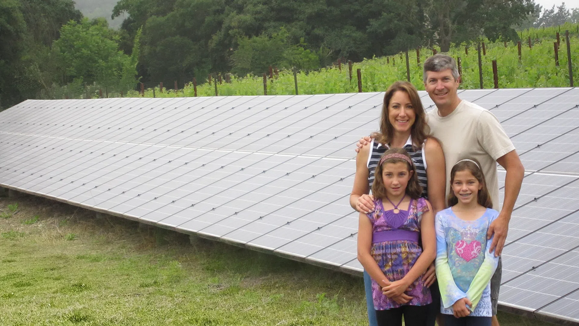 a family posing for a photo in front of a solar panels at their napa home