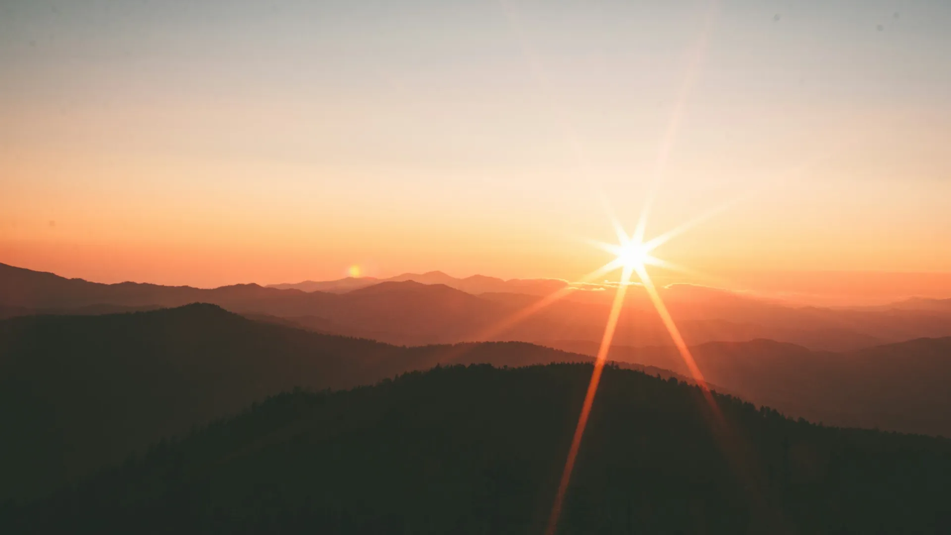 a sunset over a mountain range