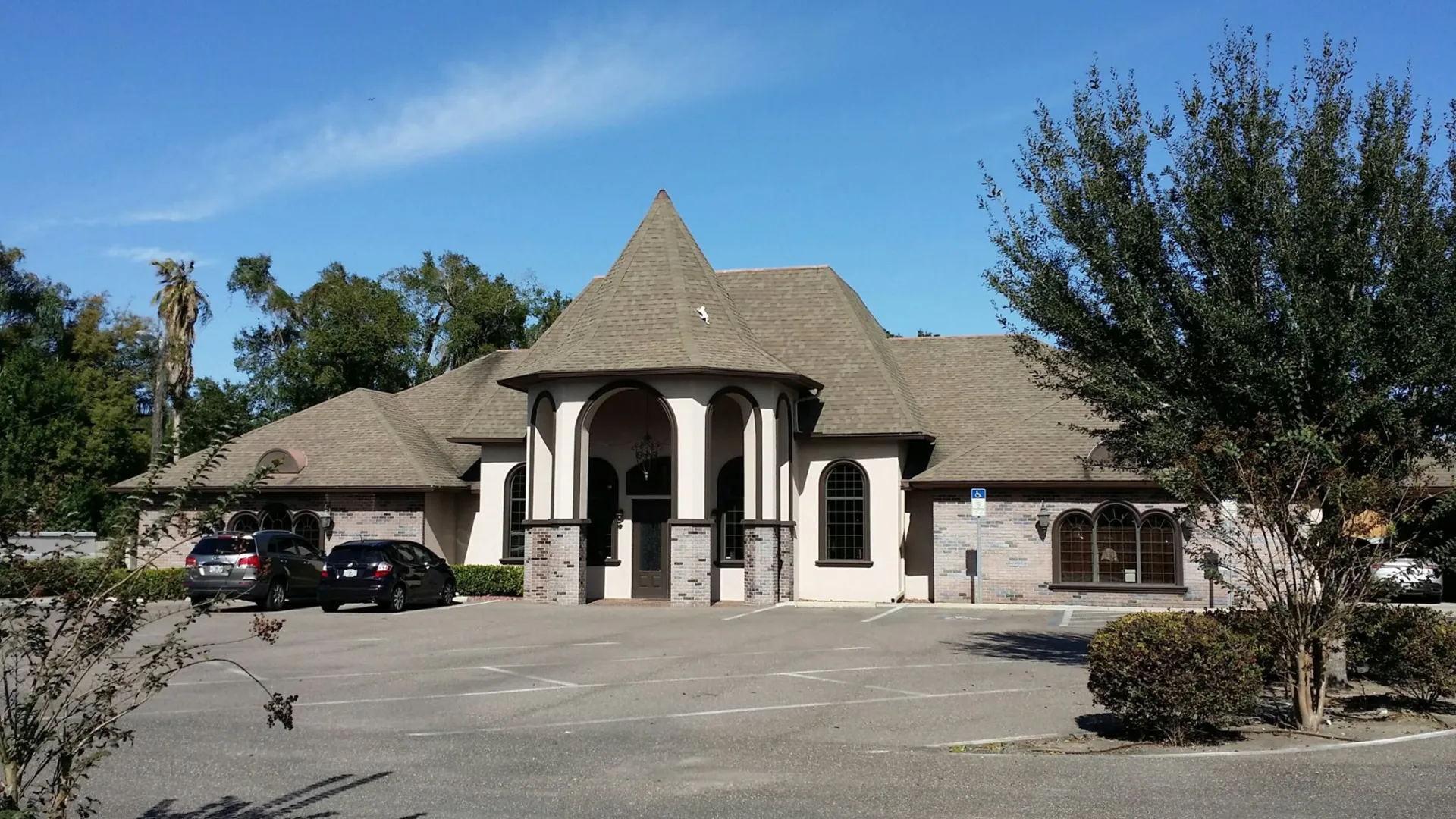 a house with columns and a parking lot