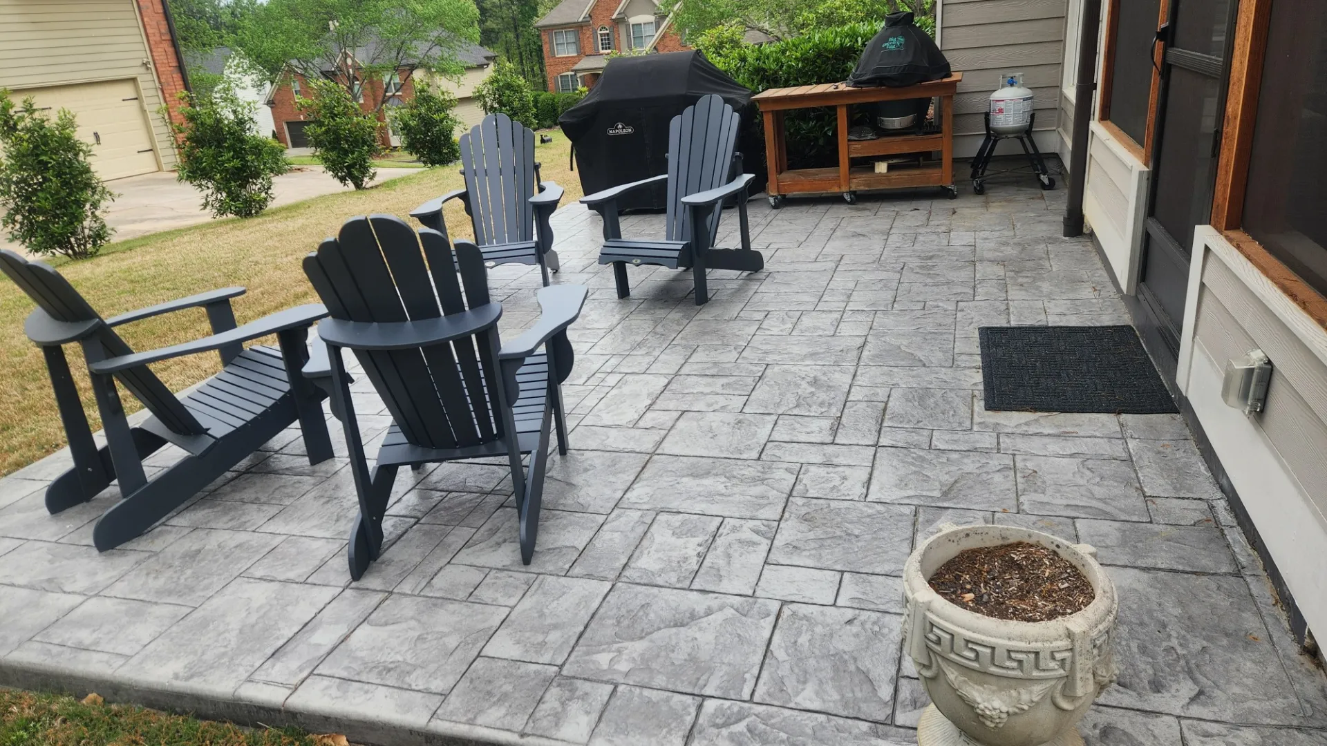 a patio with chairs and a fire pit on it