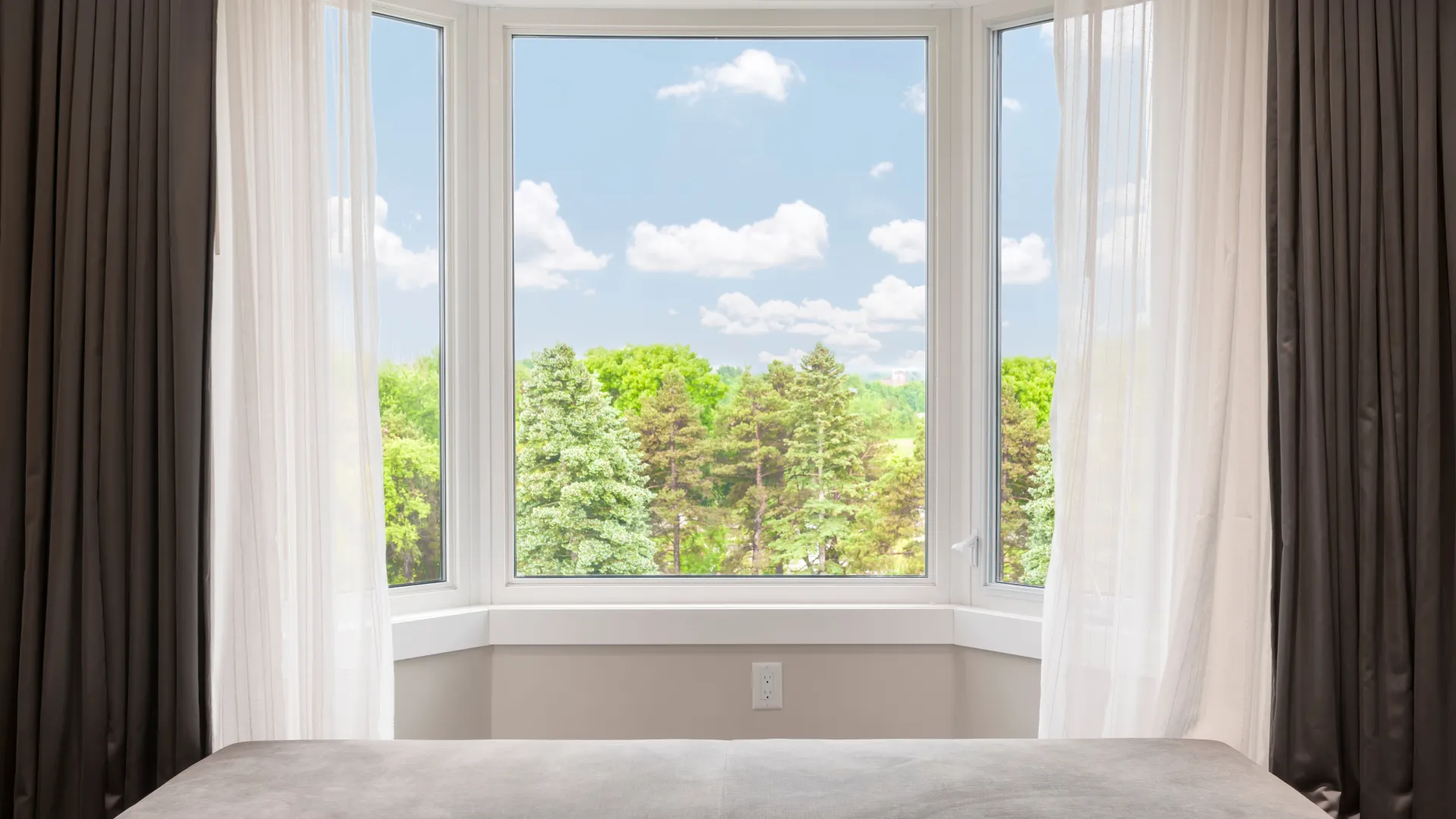 a window with a view of trees and the sky