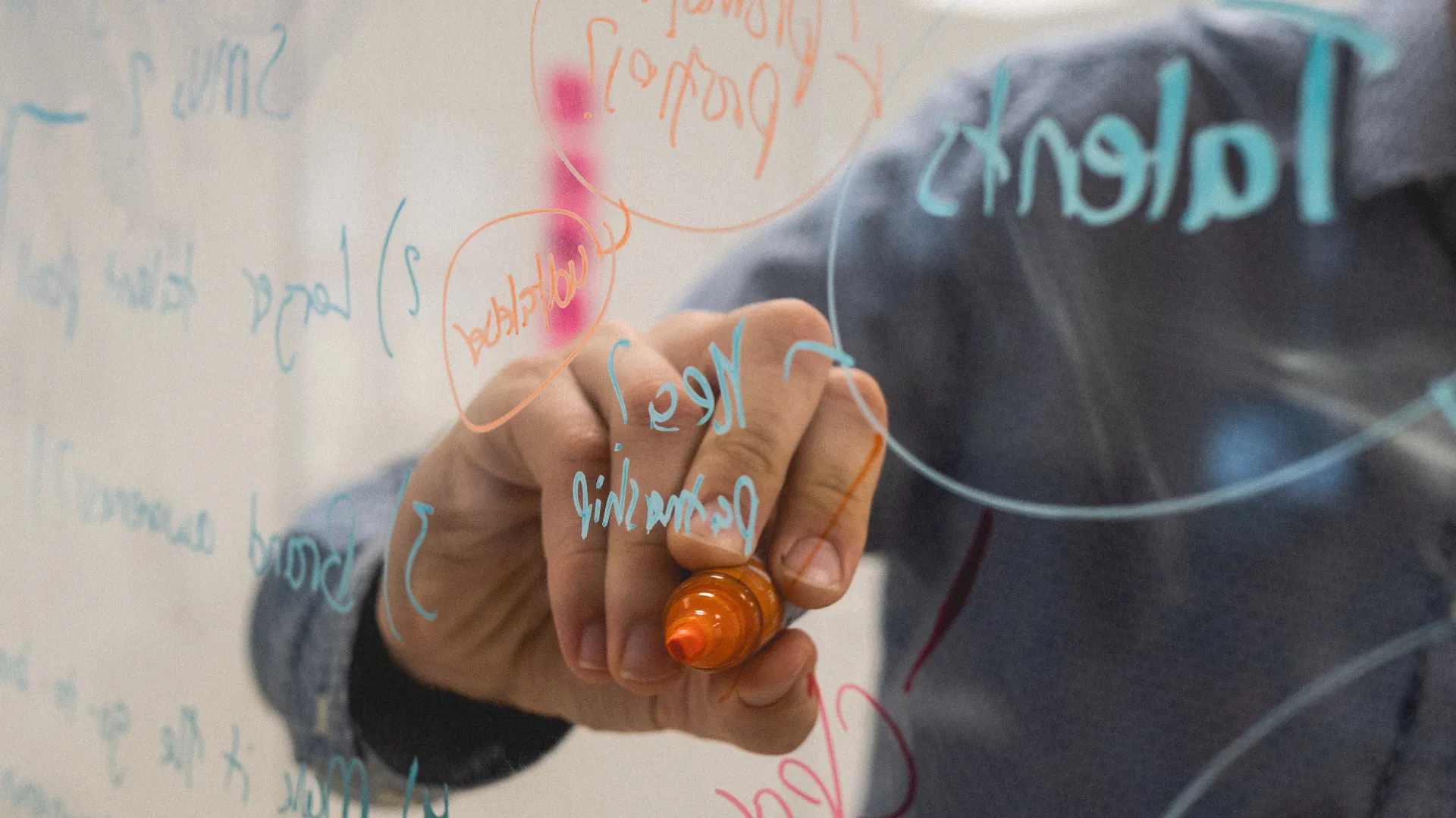 a person writing on a whiteboard