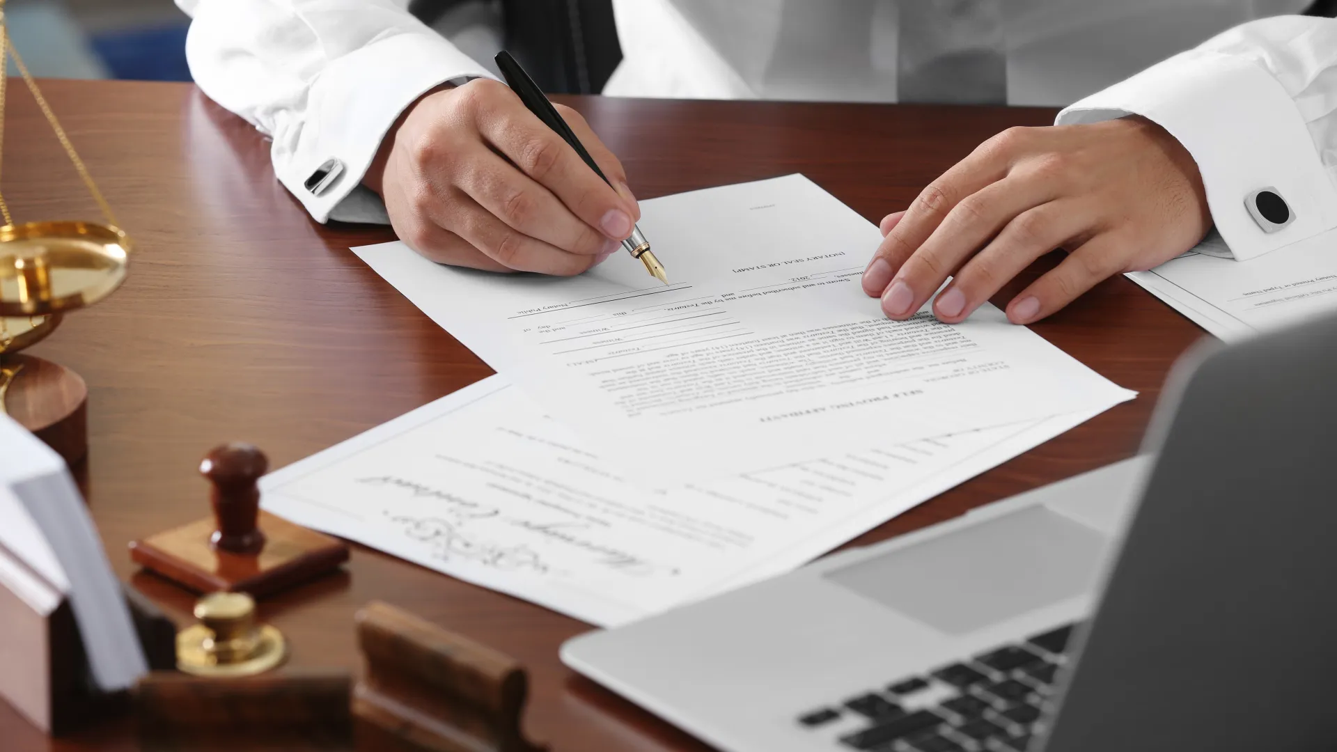 a man in a suit signing a piece of paper