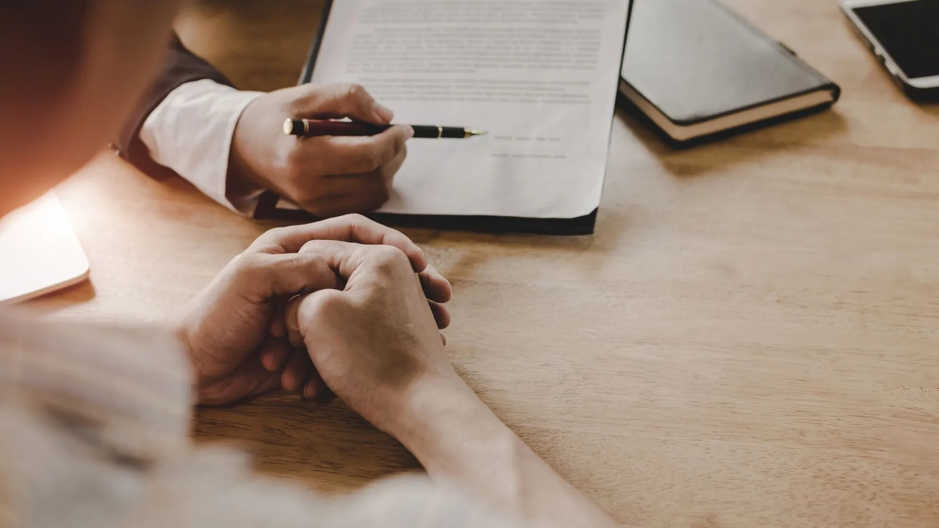 two people sitting at a table looking at a contract