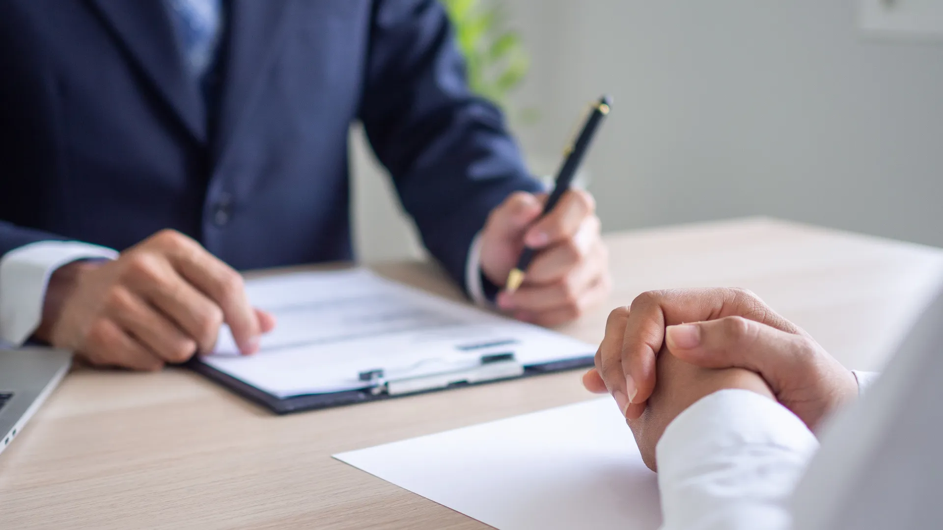 a man sitting at a table and holding a pen at a meeting