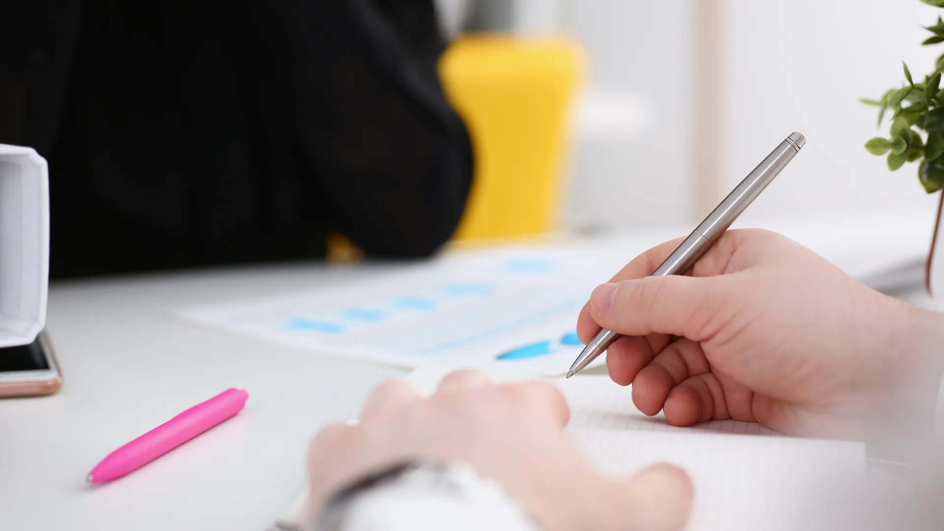 a person writing with a pen