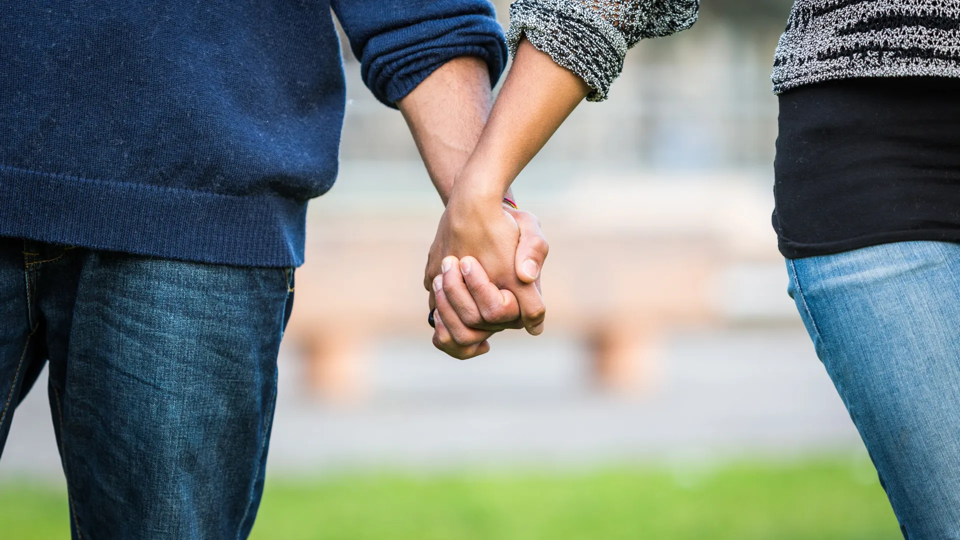 a close up of two people holding hands