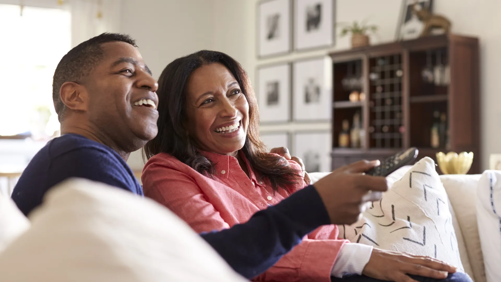 a man and a woman sitting on a couch and smiling