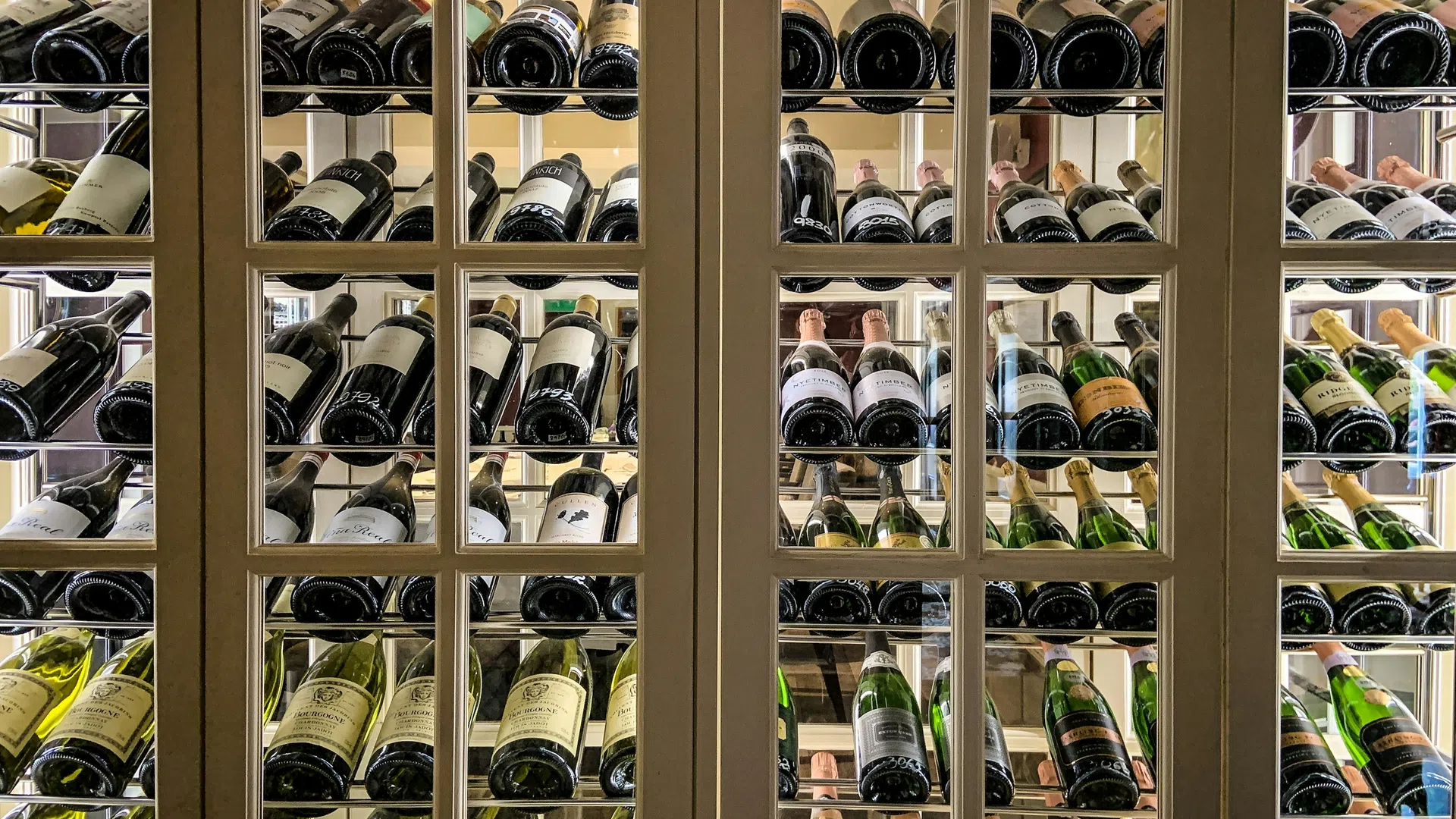 Elegant wine cellar filled with various bottles showcasing diverse labels and colors.