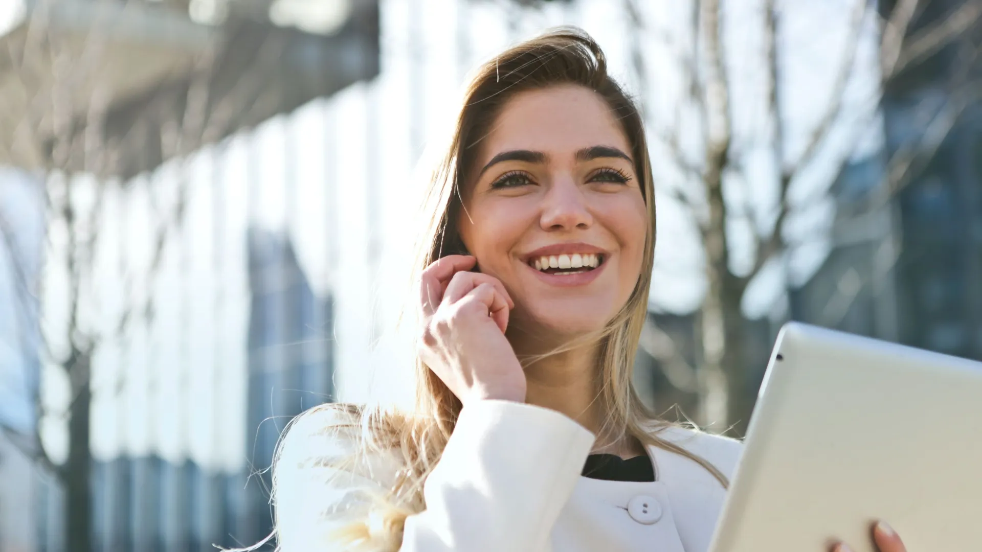 a woman with a laptop and smiling at the camera