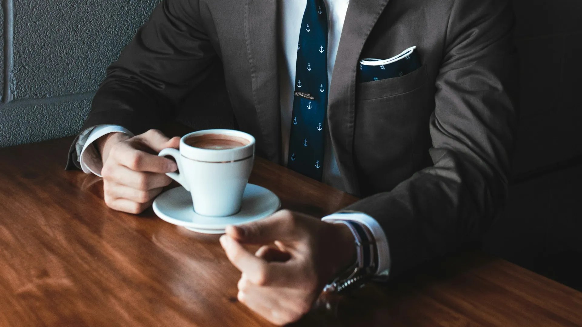 a man in a suit holding a cup of coffee