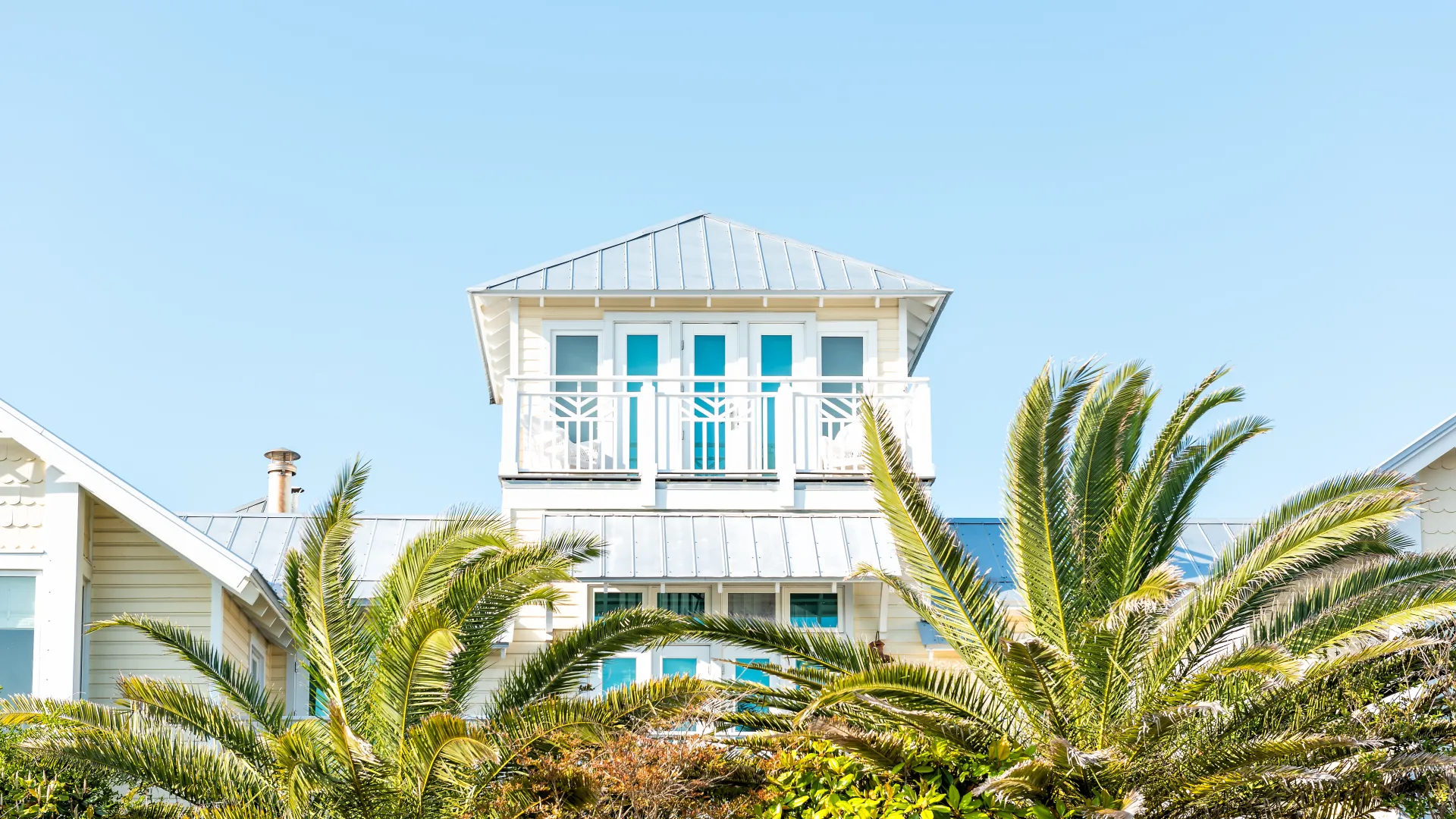 a white house with palm trees