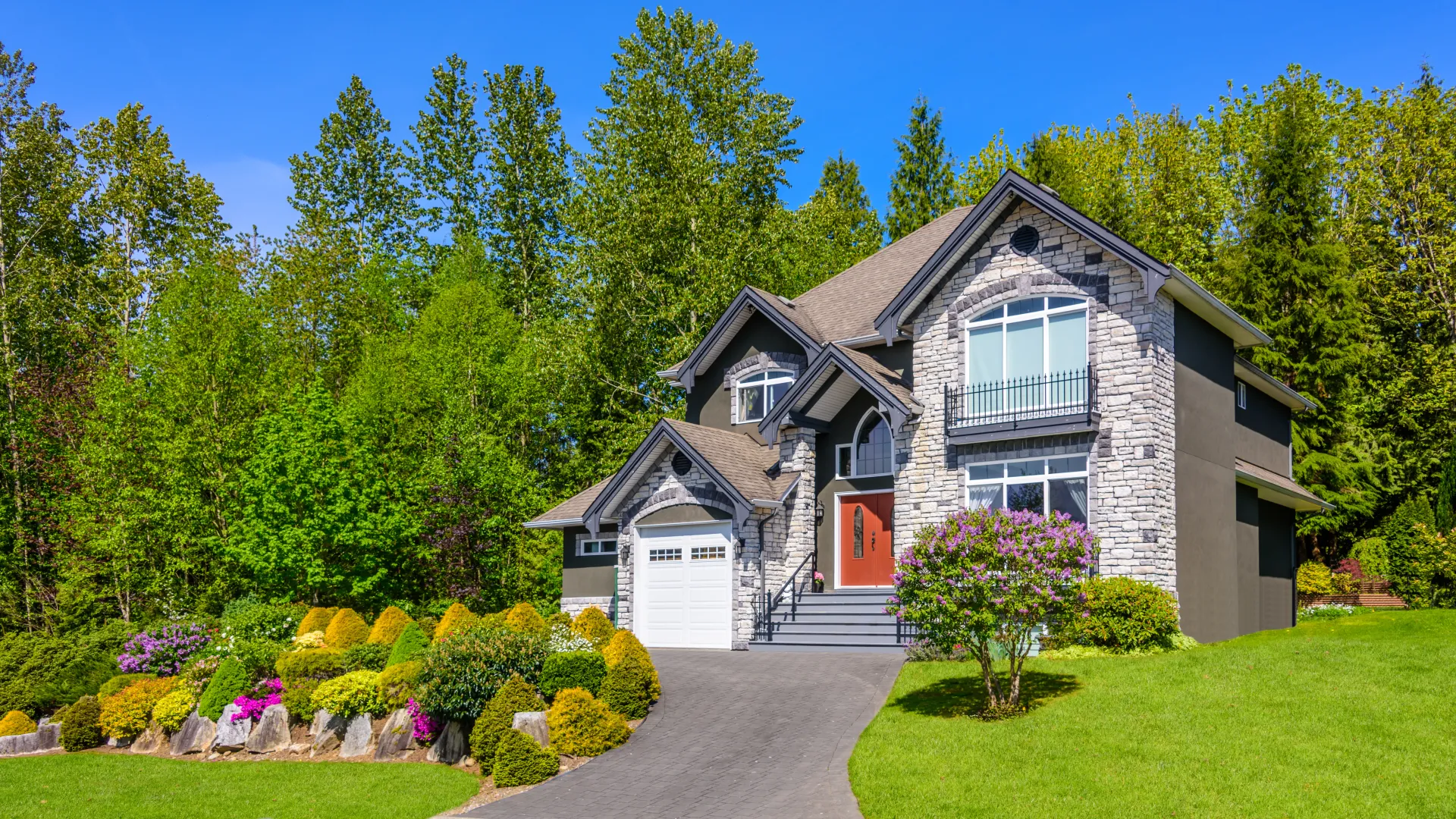 a house with a driveway and trees around it