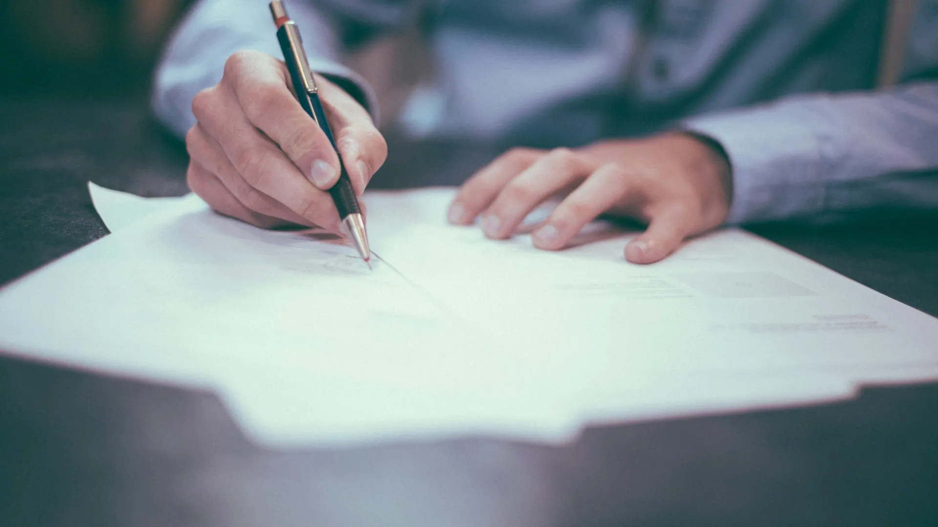 a person writing on a piece of paper