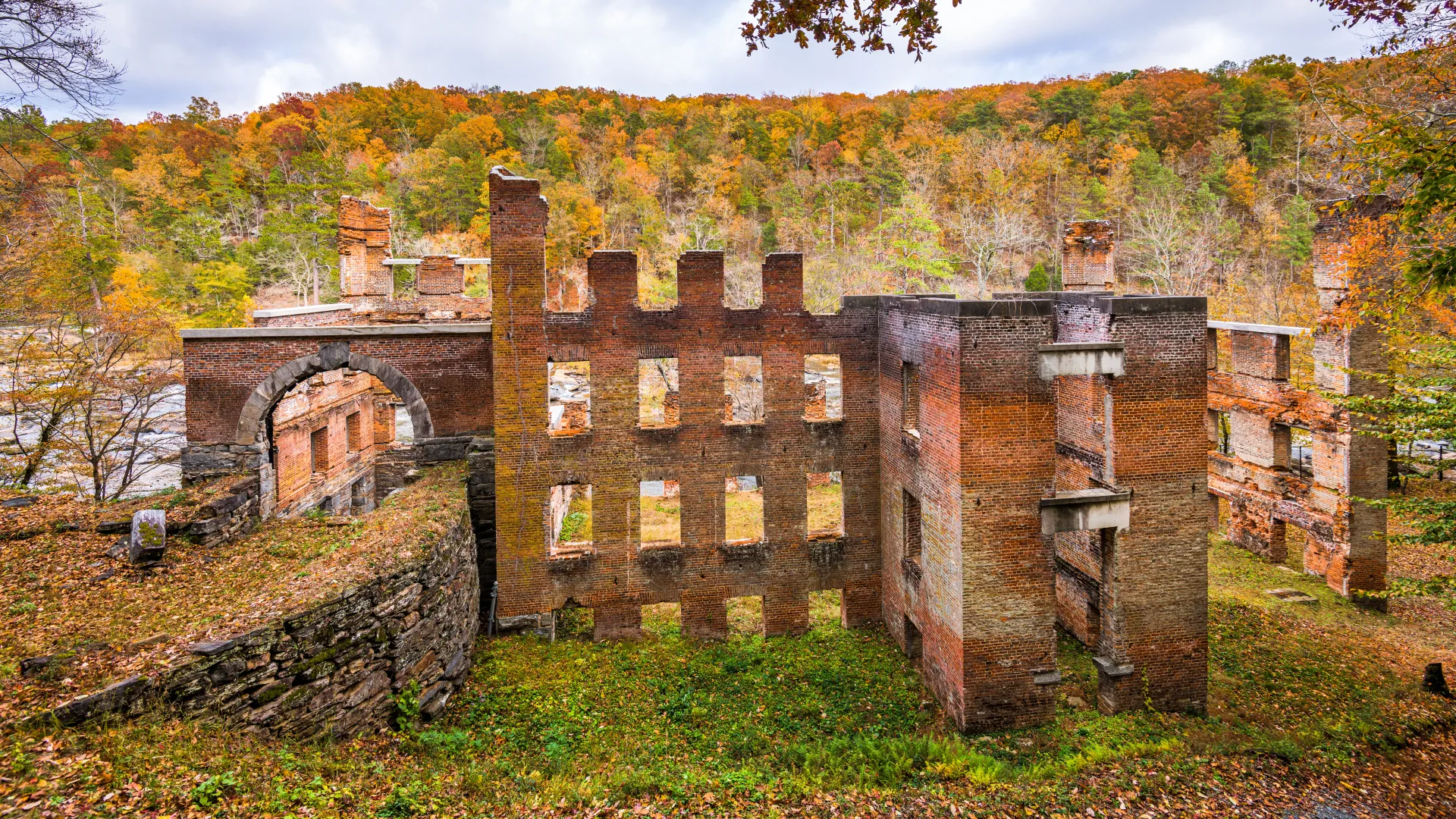 a stone building with a hill in the background