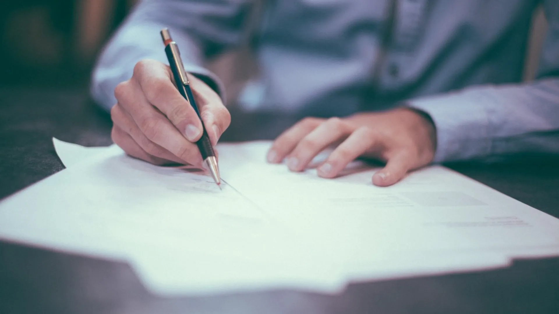 person writing with a pen