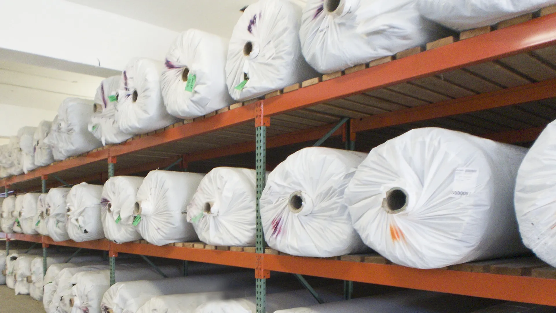 a shelf with white bags of rolled turf on it